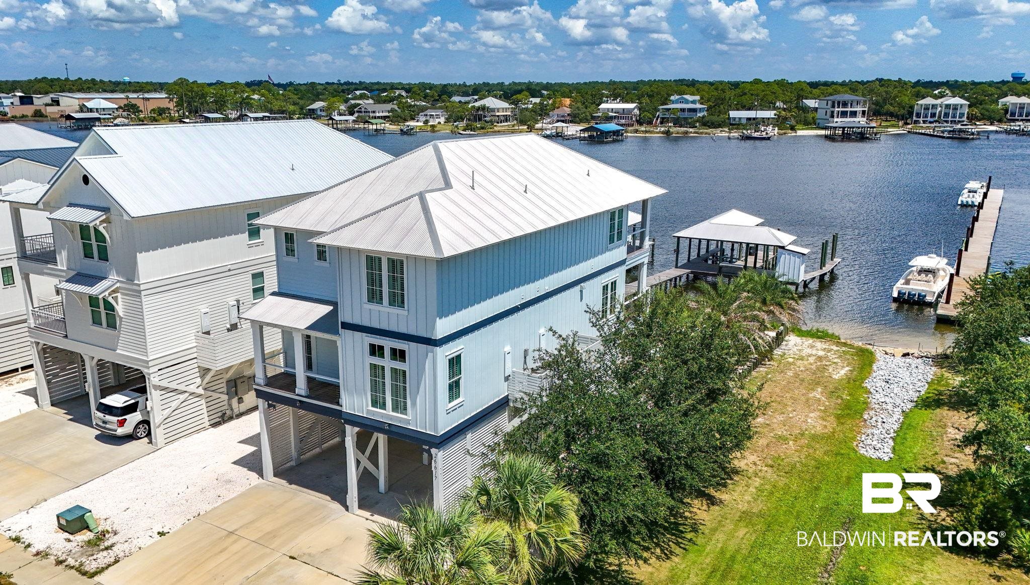 Coastal Luxury Living on Deep Water– Cotton Bayou Gem in Orange Beach!Welcome to your dream home in The Reserve at Cotton Bayou—a private, upscale waterfront subdivision in the heart of Orange Beach. This stunning 5-bedroom, 5-bathroom coastal retreat offers a perfect blend of luxury, comfort, and location—just minutes from the Gulf of America and Perdido Pass. Inside, you'll find 10-foot ceilings throughout, luxury vinyl plank flooring, crown molding, and high-end finishes at every turn. The open-concept living area features a wood plank ceiling with recessed lighting, shiplap accent wall, and French doors opening to a spacious 10x30 covered deck—ideal for indoor-outdoor living.The gourmet kitchen is a chef’s dream, featuring Cafe' stainless steel appliances, gas cooktop with custom vent hood, granite countertops, farm-style sink on a large center island, custom wood cabinetry, a striking backsplash, and coastal-modern light fixtures over the island and dining area—all creating a sleek and inviting space.An elevator serves all floors, including a wheelchair-accessible, ADA-compliant bathroom on the main level—perfect for accessibility and convenience.The primary suite is a private sanctuary with its own 10x30 covered deck, a spa-inspired ensuite with his and hers vanities, a powder station, walk-in shower, soaking tub, and a massive walk-in closet with custom shelving and drawers designed for both function and elegance.Outdoor features are just as impressive. Enjoy covered parking, durable Hardie siding, and two tankless hot water heaters. Step out back to your private beach area, leading to a pier and fully equipped boathouse with a 6,000 lb boat lift, fish cleaning station, storage room, and an additional 16x28 boat slip-perfect for welcoming friends on the water.All this is located just steps from Orange Beach’s best restaurants, marinas, shops, and directly across from the white-sand beaches of the Gulf. This home offers the ultimate in location, luxury, Buyer