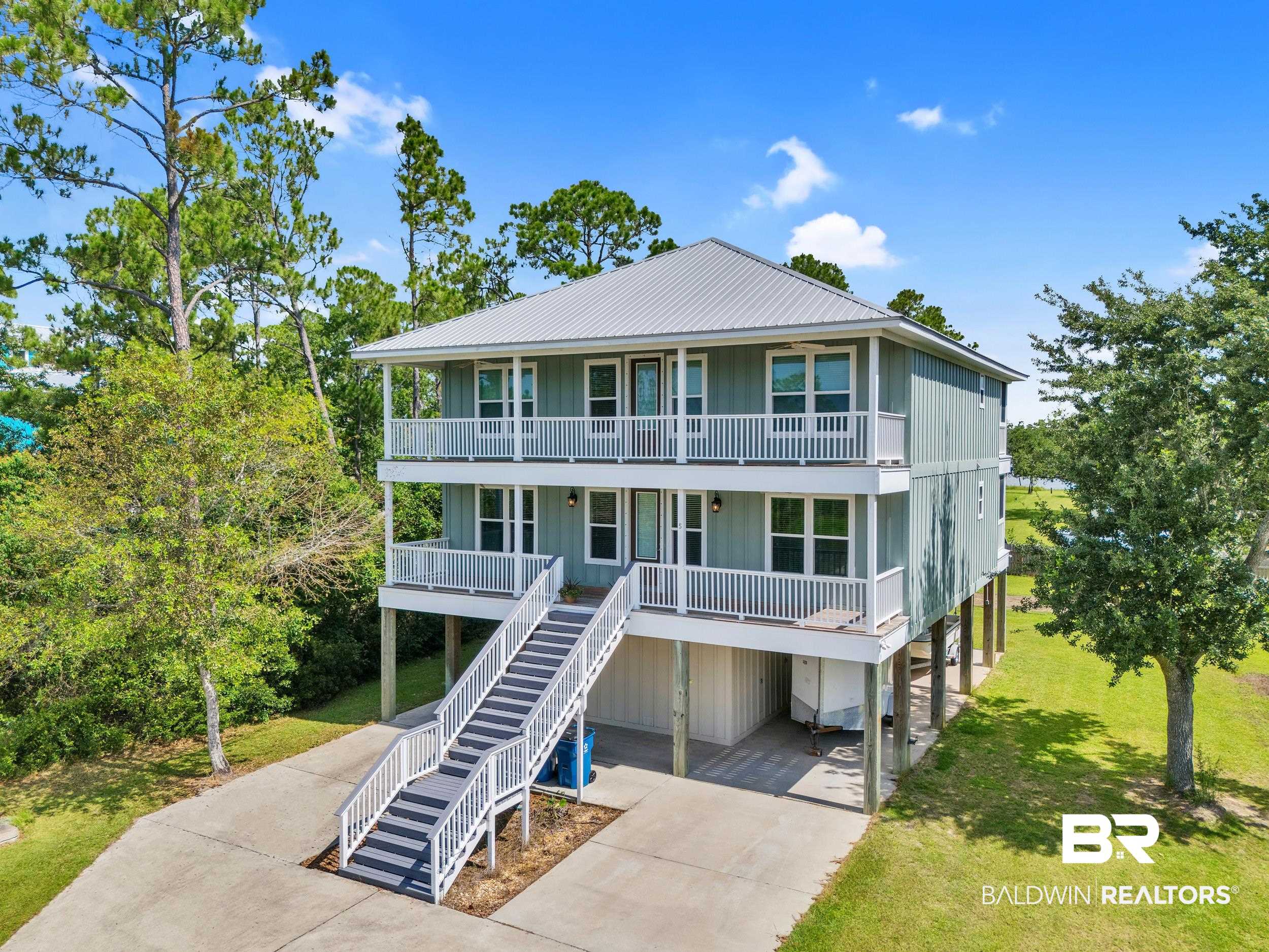 Luxury, Efficiency, and Coastal Charm—All in One Stunning Home! Welcome to your dream home in the heart of Orange Beach! This custom-built, Gold Fortified beauty was crafted with every luxury and detail in mind—and it shows. With over 3,200 sq ft of heated and cooled living space, this 4-bedroom, 4.5-bathroom home is truly one-of-a-kind. Designed for flexibility and comfort, the home features two full floors of living quarters, each offering 2 bedrooms, 2.5 baths, a full kitchen with high-end stainless appliances, and private laundry. It's ideal for extended family, guests, or even a dual-living arrangement. Step inside and experience the quality: LED recessed lighting, gorgeous tile flooring throughout, granite, hardwood, and Corian countertops, and custom closet shelving. An elevator with a 950 lb capacity and keycode access makes moving between floors effortless. Energy efficiency? Covered. With 6-inch spray foam insulation, two Trane AC units, and an instant gas water heater, your comfort is maximized and your utility bills minimized. Peace of mind comes standard with hurricane impact windows and fabric door protection, as well as a fire suppression sprinkler system. Enjoy the outdoors on one of four spacious decks, each with ceiling fans, or cast a line from your lot’s freshwater canal—perfect for casual fishing (non-navigable). There's also a large downstairs workshop and a full outdoor sprinkler system to keep the grounds lush. Whether you're looking for a luxurious single-family residence or a unique space for multi-generational living, this is a rare opportunity you don't want to miss. Homes of this caliber—packed with upgrades and built with lasting quality—don’t come around often. Schedule your private showing today and see what exceptional coastal living looks like!  Buyer to verify all information during due diligence.