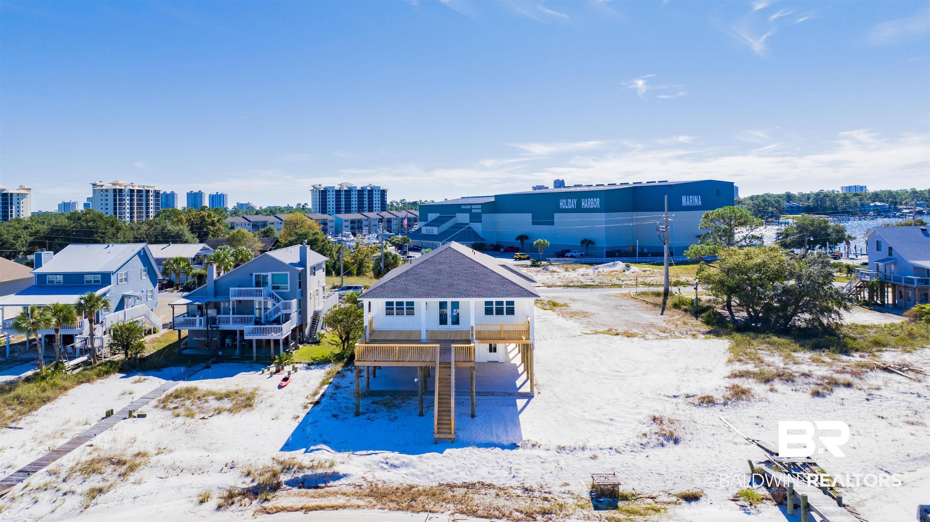 STUNNING NEW CONTRUCTION, WATERFRONT HOME LOCATED DIRECTLY ON THE INTRACOASTAL WATERWAY AND IN THE HEART OF PERDIDO KEY! COMPLETION EXPECTED AUGUST TO SEPTEMBER 2024! This remarkable home offers luxurious living with unparalleled sunset views of the Intercoastal Waterway. Currently under construction and close to completion, this home boasts state-of-the-art design with high-end finishes and an elevator for convenience and accessibility. Offering 4 bedrooms and 3 bathrooms, the floor plan features high ceilings, abundant windows and an open living area leading to a grand covered balcony showing off stunning water views.  The grand balcony also features a staircase leading down to your private waterfront.  The kitchen is outfitted with sleek quartz countertops and top-of-the-line Bosch appliances plus huge walk-in pantry. Bathrooms showcase beautiful white subway tile surrounds, complemented by white quartz countertops.  Underneath, the home provides ample storage space which would accommodate multiple vehicles, watercraft, and even a golf cart- which would be perfect to make a trip right down the street to Holiday Harbor and Sunset Grille. This is a rare opportunity to own a brand-new, stunning direct waterfront home on the Intercoastal Waterway.  NO HOA allows you flexibility for primary residence or vacation rental. Don't miss your chance to make this your dream property TODAY! Buyer to verify all information during due diligence.