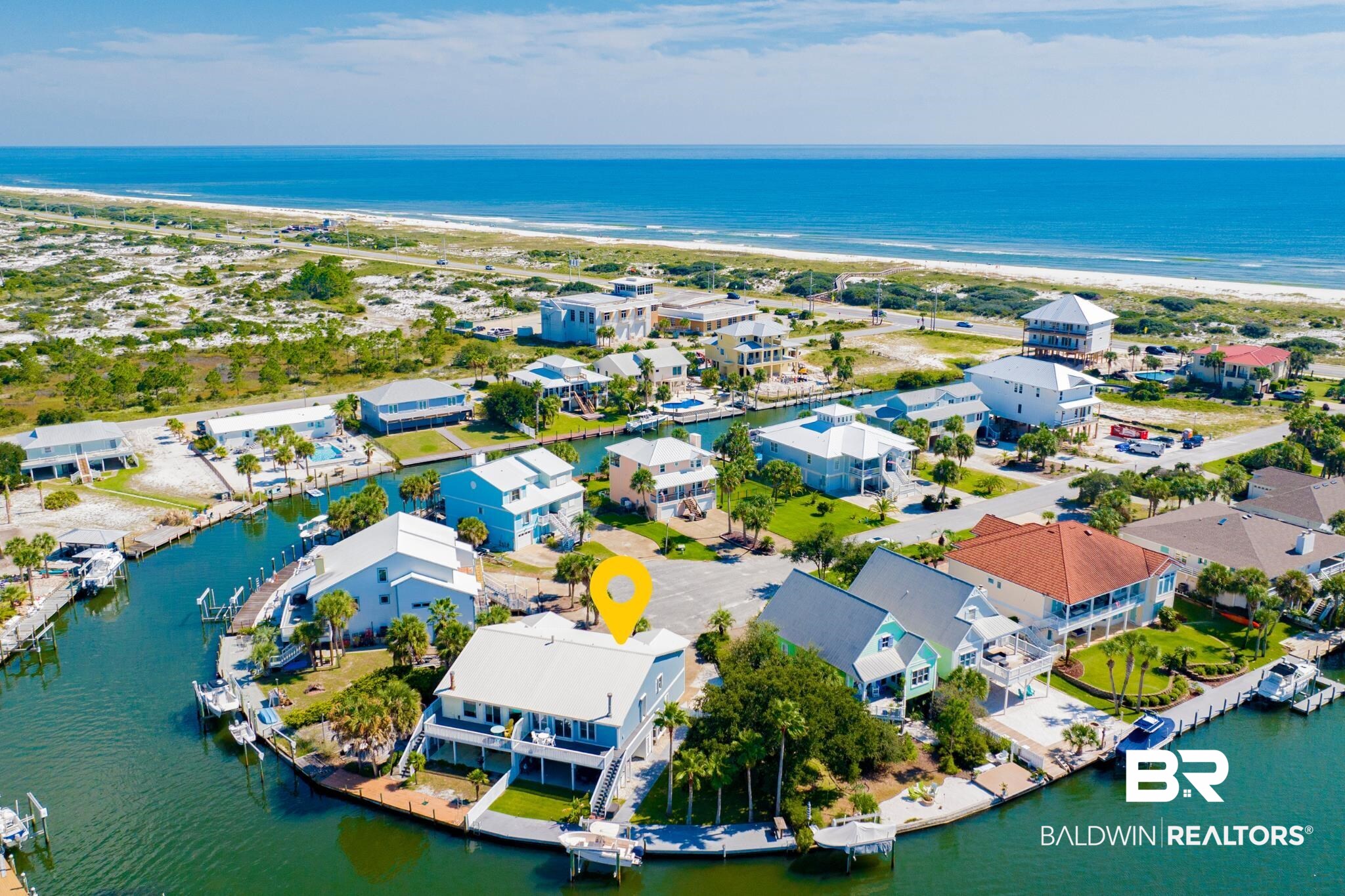 WELCOME TO TRUE PERDIDO ISLAND LIFE – ON THE WATER! THIS CANAL HOME HAS AN INCREDIBLE LOCATION NESTLED AT THE END OF A CUL-DE-SAC OVERLOOKING ADJOINING CANALS FOR EXPANSIVE WATER VIEWS AND SPECTACULAR SUNSETS!  THIS IS TRULY A BOATER’S DREAM WITH 86’ OF WATERFRONT WITH BOAT LIFT ON DEEP, PROTECTED WATER WITH QUICK ACCESS TO OLE RIVER AND THE GULF OF MEXICO.  ENJOY BEAUTIFUL BEACHES JUST A SHORT DISTANCE ACROSS THE STREET WHERE 1.5 MILES OF PROTECTED STATE PARK SEASHORE AWAIT YOU…THIS IS THE BEST OF BOTH WORLDS!!! This stunning, 4-bedroom 3-bath, duplex residence has been well-maintained by the owners and updated both inside and out.  The exterior shines with a fresh coat of paint, a durable metal roof, and lovely landscaping maintained by a newly installed irrigation system. The large covered outdoor living area, complete with an outdoor kitchen, is great for entertaining, enjoying spectacular sunsets or watching the dolphins and manatee cruise the canal.  Inside the home, enjoy a beautifully redesigned kitchen featuring brand-new appliances, quartz countertops and white cabinetry. The spacious living area, complete with high ceilings and a cozy fireplace, provides a warm and inviting atmosphere, while sliding doors lead you to a generous balcony overlooking the serene canal where you can enjoy morning coffee or evening relaxation. Retreat to the primary bedroom, which features its own private balcony, and an en-suite bathroom equipped with double vanity sinks for added convenience. Taking the unique spiral staircase to the fully remodeled downstairs area, you will find a second living area with convenient sleeping arrangements and beautifully remodeled full bathroom. This lower-level has private access and can also serve as a separate suite for guests or a recreation/game room – the possibilities are endless. The oversized 2-car garage has plenty of space for vehicles, a small boat, jet skis, kayaks and more!  Don’t miss out on this rare opportunity! Buyer to ver B