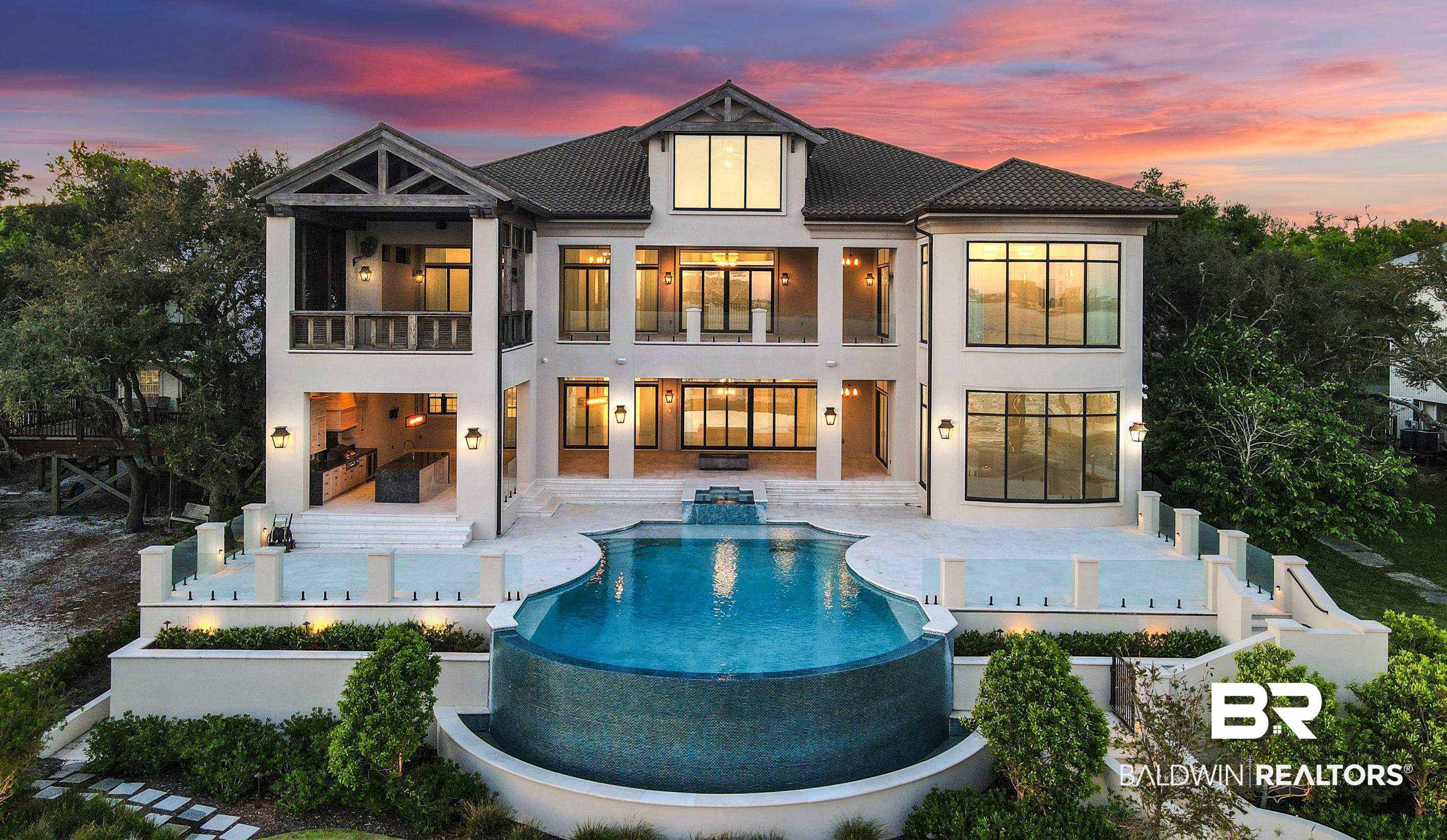 Extraordinary Waterfront Estate with private deep water pier. This 10,000+ sq ft gated 4 bedroom home will take your breath away, nestled in a coveted location in a quiet Orange Beach neighborhood. From the marble floor elegant entry, through the spacious living area, to the amazing outdoor waterfront spaces, this home is a masterpiece for exceptional coastal living. The architectural design of this home highlights  floor to ceiling windows in every room with expansive views overlooking Bayou St. John. Perfect for entertaining or just relaxing with the family, the home showcases a chef’s kitchen with Wolf and Subzero appliances, marble countertops and a butler's pantry. Expansive state of the art outdoor living space offers Spa, waterfall zero edge gunite pool, a well-equipped outdoor kitchen for resort style indoor/outdoor entertaining surrounded by an established landscape border for ultimate privacy. Make your way down to the large boathouse with composite flow through decking, 10 ton boat lift and double jet ski floating dock. Two primary bedrooms (each 1120 sq ft) with separate sitting areas, remote controlled drapery, walk in closets with custom designed cabinetry. A grand staircase, exquisite chandeliers, study, 2 laundry rooms and 3+ car garage make this home truly exceptional.