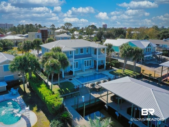 Great opportunity to own BOTH sides of a DUPLEX on the popular Marina Road on one of the largest navigable canals in Orange Beach. Both the East and West side of this duplex mirror image one another. Both offer 4 bedrooms, 4.5 baths, tile, wood and carpet flooring, large living and dining areas, high ceilngs, granite countertops, custom cabinetry, SS appliances, gas range, large walk in showers in primary and jacuzzi tubs, large covered porch just off the living areas, private balconies off the primary suites overlooking the Outdoor Pool and Marina, double car garages. The Boat house is spectacular and both sides have 2 slips - 2 65ft uncovered slips, 2 24ft covered slip (one w/ a 10k lb lift). This property has been well maintained. Easy to show!