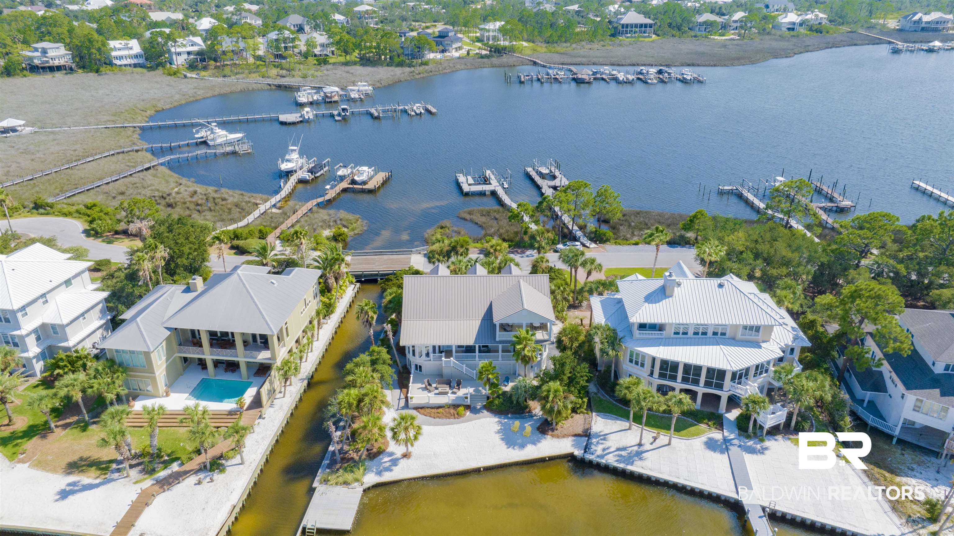 This DREAM home is sold fully furnished including art work and decor! All you need is your clothing to come and enjoy paradise! This immaculate home has been remodeled! This ONO Island water front home offers expansive and incredible water views from it's serene and private setting which includes a beautiful white sandy beach! This 3BD/4.5BA with bunk room.  Main floor which includes master on the westside of home to take advantage of the water views, natural light and amazing sunsets! The other two extra large bedrooms are on the 3rd floor of the home with awesome water views also, All the three bedrooms have private bathrooms to accommodate family and guest. Home has two sets of washer and dryers with an extra large Landry room and butler pantry.  Spacious deck offers plenty of entertaining area, space to enjoy the sunset views or relax and watch the boats go by. The dock, two boat lifts and a  jet ski lift on deep water in the harbor..   Expansive lot full of the island's vegetation and serene beauty. Ono Island is a private gated island with 24 hour security. Option to join the on site island recreation center which includes lighted tennis and basketball courts, weight room, indoor and outdoor pools. The island also has a boat ramp. Coastal living at its best!