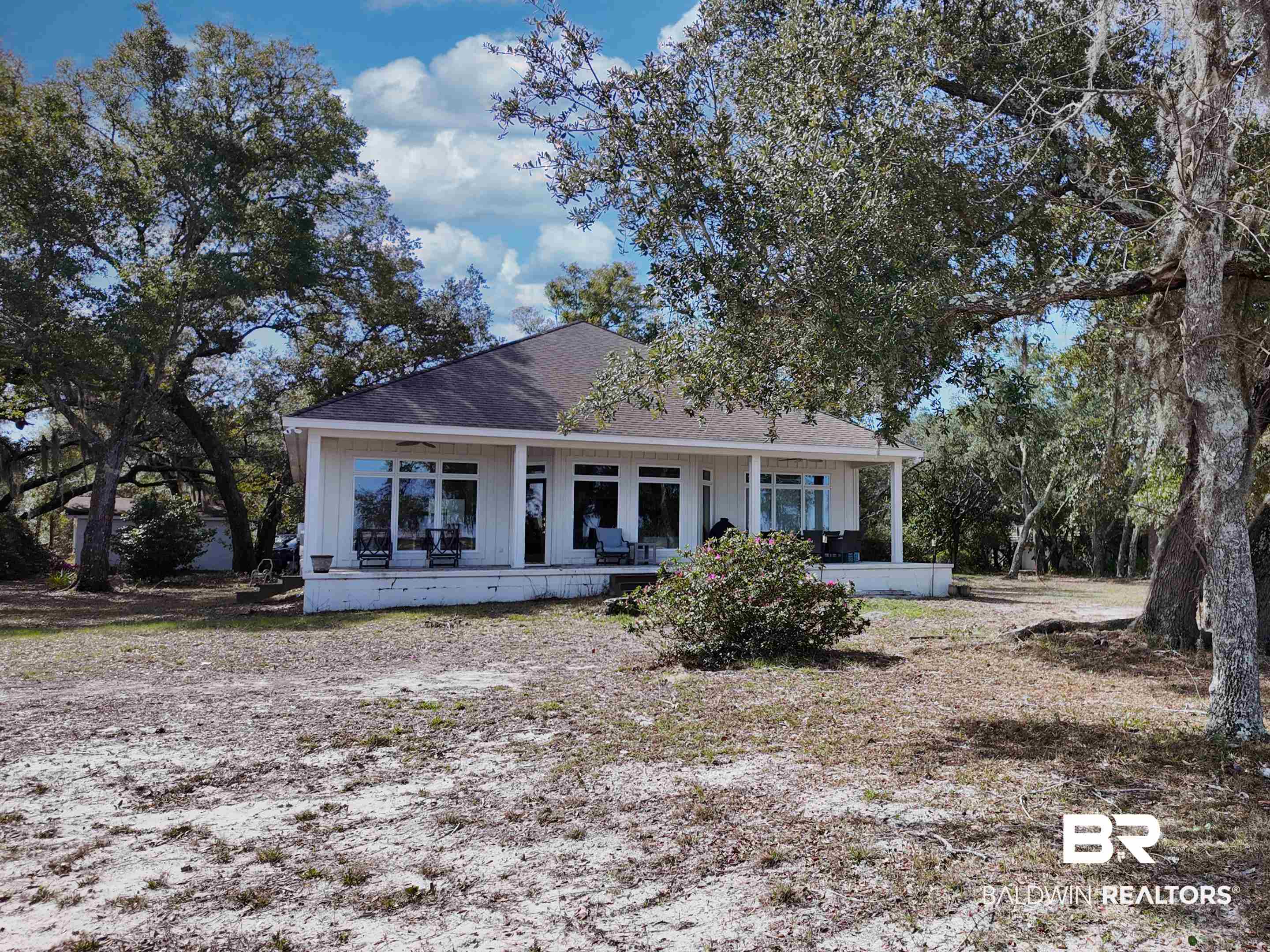 PRIVATE & UNIQUE SETTING on this special and rare piece of paradise with lots of southern and coastal charm!  Truly a perfect place for someone wanting privacy & enough space for a family compound. Enter this beauty by way of a long, private drive with mature, moss draped oaks and huge azaleas!  These mature oaks frame the majestic water views on Bay La Launch & Arnica Bay!  This rare, coastal property is 3+acres with over 200ft. of waterfront.  The property includes a 3 bedroom/3 bath custom cottage which was designed to bring these spectacular views into the home!   Enjoy sunsets at the pier with boathouse.  There is a 20,000 lb boat lift with 50 amp service. The property also has a high-ceiling, multi-use 40x40 storage building equipped with water and power.   The property consists of six lots.