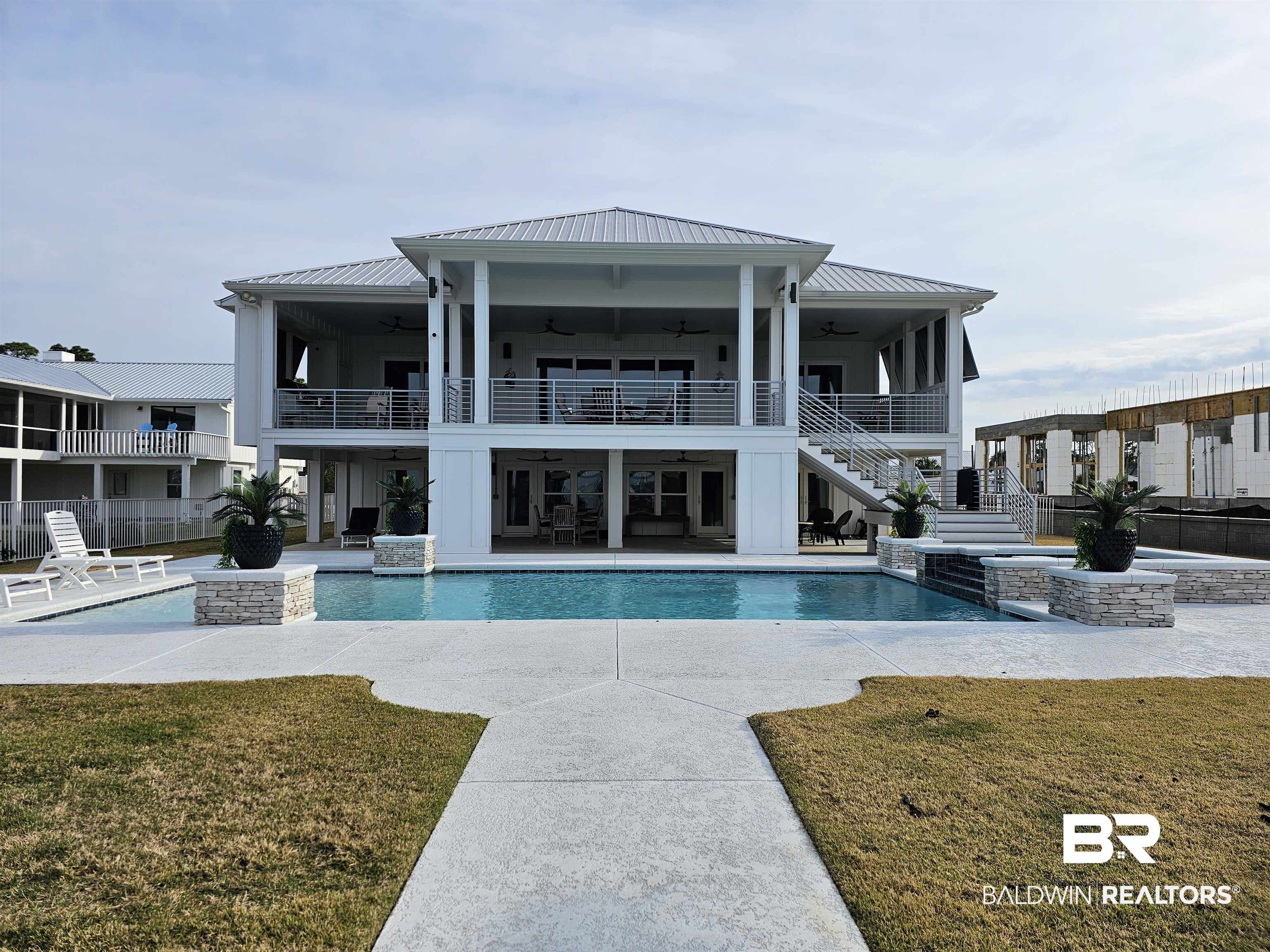 Nestled within the prestigious Burkart Estates, overlooking the serene Terry Cove, stands this splendid 2021 remodeled waterfront home. The inviting front drive is lined with Sylvester Palms, and the inside is a testament to exquisite craftmanship and design. Step inside the beautiful custom front doors to a sanctuary of open design and water views. The upper level has 3 bedrooms. 2.5 bathrooms, laundry and an office. Multiple rooms offer access to the large covered porch.The heart of the home is the sprawling open main area with oversized den including a beautiful backlit, built-in sized for 86" TV, dining area, and kitchen combination. The dining area is graced with a stunning designer chandelier  casting a mesmerizing glow over the elegant surroundings. No detail has been spared in the chef's kitchen, which features custom cabinets, granite countertops, wine cooler, ice maker and top-of-the-line Sub-zero 48" cabinet front refrigerator and a gas range. The primary bedroom suite offers a tranquil retreat, with panoramic views of the pool and the glistening waters beyond. The spacious primary bathroom boasts a large walk-in shower, stylish stand-alone tub and extensive storage in the  designer walk-through closet. An elevator provides easy access to the lower level where a lovely galley kitchenette, bedroom, bathroom, 2nd office/room, and a generously sized den and storage closet await. This home easily accommodates 3 cars in the two garages, or workshop space that opens to the water view. The outdoor space includes the 1200+ square foot upper porch, complete with outdoor kitchen, the lower patio overlooking the beautiful, heated saltwater pool and hot tub with outdoor wet bar, and private pier and dock with deep water access and slip for a large boat, covered decking and lift for boats up to 35ft and a jet ski lift with 50 amp power and water. Minutes to the islands and Gulf. Gold Certified.  Don't miss this incredible home. More photos coming soon.