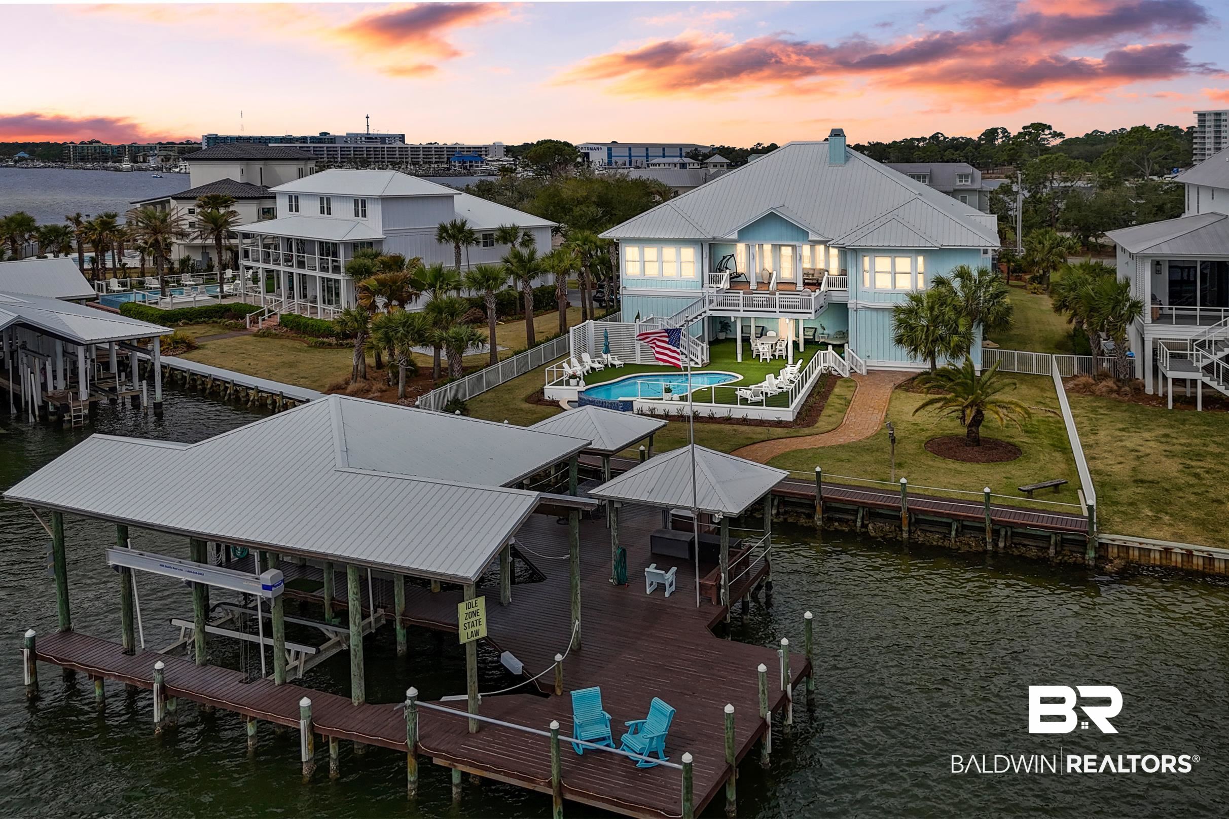 Welcome home to this beautiful waterfront estate perfectly situated near the Alabama/Florida state line with expansive views of Bayou Saint John, Terry Cove, Ono, Robinson & Bird Island and the sights of Perdido Pass in Orange Beach. This 4-bedroom/3.5-bath home offers numerous entertaining spaces in a serene setting with easy access to town and the Gulf of Mexico. The designer-level kitchen includes high-end stainless steel appliances such as a sub-zero refrigerator and freezer, dishwasher, double ovens, gas burning stove and wine cooler. In the private owner’s suite, you will find two large walk-in closets, a luxurious ensuite bathroom with double vanities, a walk-in shower with massaging rain shower head and custom tile work. On the main level you will find 3 additional bedrooms each with large walk in closets, 2 full baths along with a dedicated office with built in desk and book shelves and cabinets. Outside reveals the true magic of this home from the newly landscaped yard leading to the recently installed pool with a waterfall zero edge, new private 3,000 sq ft boat dock in No Wake Zone with 33k lift and 15k lift and water depth from 4'-11', cleaning station, Sonos speakers on deck & pool area, security system w/ four cameras all controlled by app, secondary seawall, as well as space for dining. Downstairs also features a sauna, 3600 Sq. Ft. enclosed garage w/ 3 garage doors, workshop and tackle prep area and closed in storage space and a 1/2 bath with easy access from pool and pier. Additional construction upgrades include high impact and hurricane rated Anderson windows and doors, elevator, three gas on demand water heaters, walk-in/climate controlled attic space and 22KW gas generator. This one-of-a-kind home is coastal living at its finest!