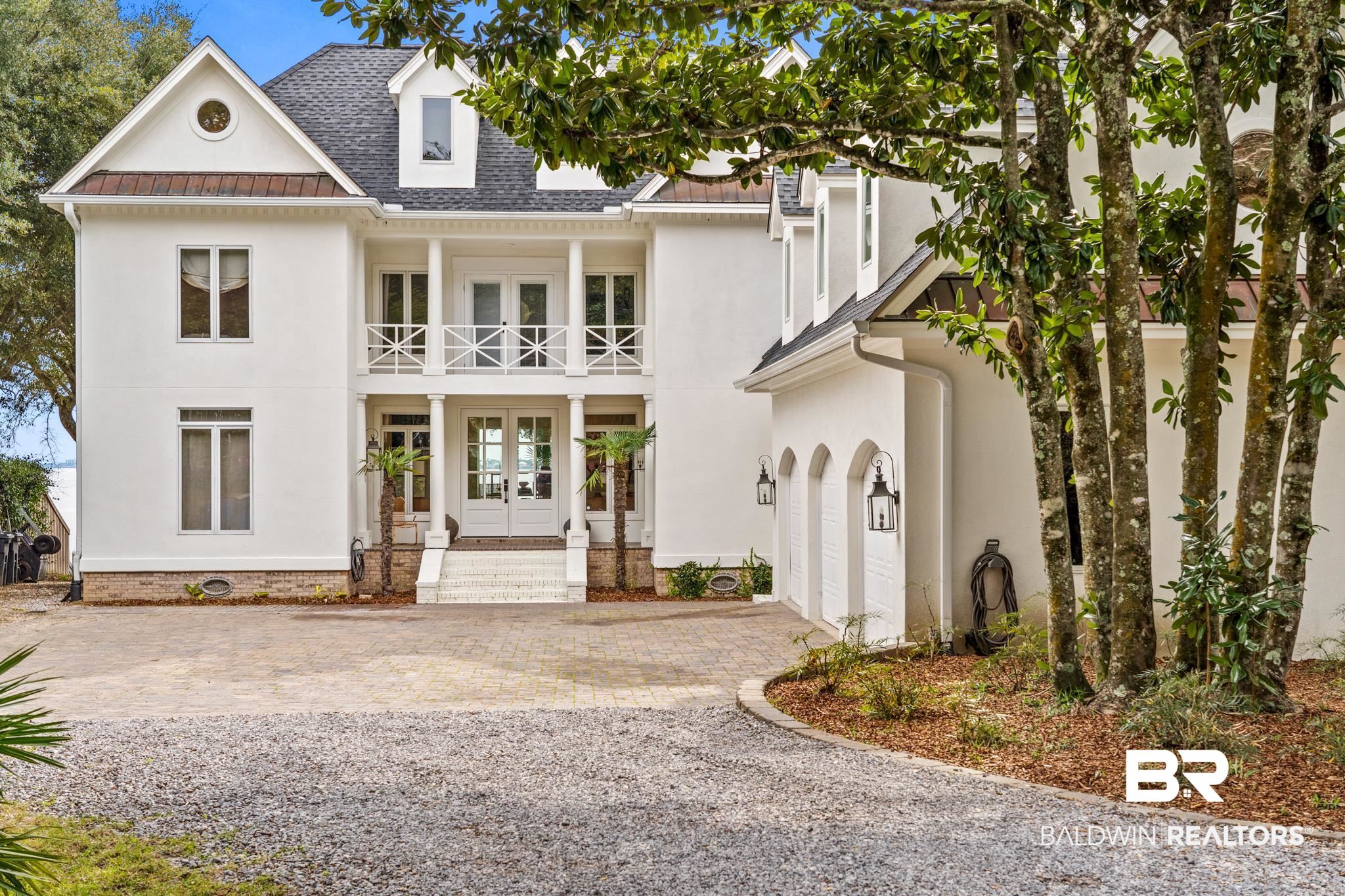 Indulge in the epitome of luxury living at 5448 E Oak Ridge Drive in Orange Beach, Alabama. This waterfront oasis offers breathtaking panoramic views of Bayou St. John and Perdido Bay, providing a coastal lifestyle that dreams are made of.  Nestled on a spacious .73-acre lot adorned with live oaks and magnolias, this exquisite home boasts 91 feet of waterfront and a heated salt-water gunite swimming pool, perfect for enjoying the coastal breeze and sun-kissed days. With a whole house generator and no flood zone worries, peace of mind comes standard.**The seller also has approved permits for expanded sea wall and future pier/boat house.**  Wake up to stunning sunrises visible from every corner of the back of the house, including the primary bedroom suite. This four-bedroom, 4.5-bathroom residence has been thoughtfully renovated and expanded, featuring a main floor primary bedroom, each bedroom with its own ensuite bathroom, and the addition of a home office and third-floor bonus room with den/bedroom and closet.Recent upgrades include a fortified roof ('22), new stucco on the entire house, updated electrical panel and transfer switch, new HVAC unit, and new windows along waterfront and some on front of home. The kitchen has been tastefully updated with Bosch appliances, gas cooktop, and a stylish backsplash, complemented by new hardwoods on the first level and wall-to-wall seagrass on the second level.   Storage is abundant, with a 3-car garage, walk-in attic storage, a large laundry and pantry on the main floor, and a climate-controlled storage room ideal for boating, fishing, and pool gear.    There is no Homeowner's Association, but residents can join the Bear Pointe Association for $350 a year, granting access to the beach and boat launch.    Experience the ultimate in coastal luxury living at 5448 E Oak Ridge Drive. Check out the virtual tour! Property expected to become active April 2nd.