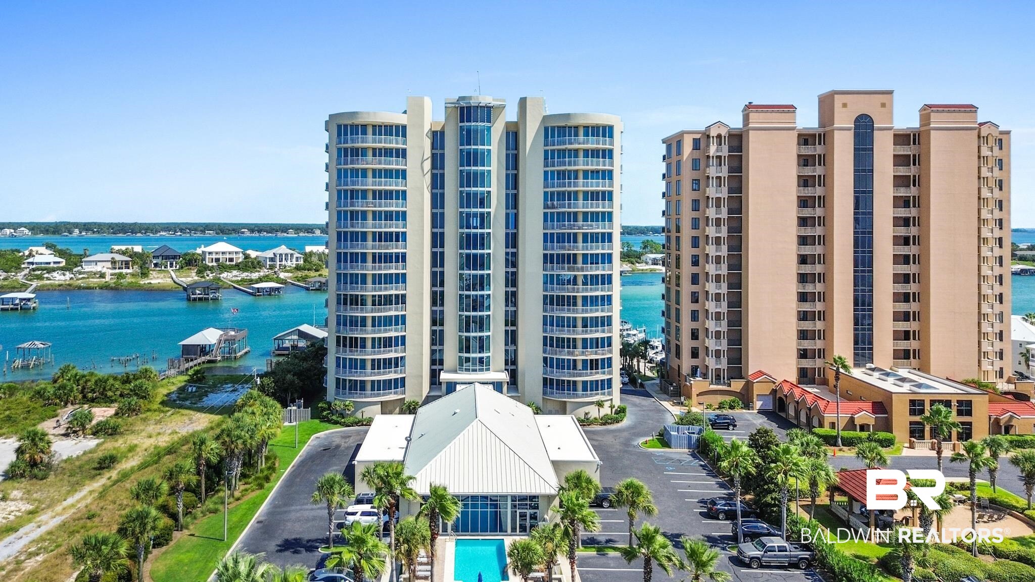 Welcome to Vista Bella PH2, one of the finest and most exclusive luxury condos along the Alabama Coast! This beautifully updated and furnished east corner penthouse unit spans 4,550 SF, comes with a thirty-foot deeded boat slip, and offers expansive views of the Gulf of Mexico, Ole River, Perdido Bay, and Bayou St John. Upon entering the condo, you are greeted by ten-foot ceilings and are immersed in an abundance of natural light flowing in from the northern and southern exposures that are lined with floor-to-ceiling glass. As you make your way through the eight-foot solid panel doors, you will find two master suites, a bonus room that is used as a sixth bedroom, and a spacious kitchen that effortlessly flows into the massive waterfront living area, creating the ideal space for entertaining family and friends. The primary master suite overlooks the vast Orange Beach waterway and features direct balcony access, his and her vanities and toilets, a freestanding tub, a large walk-in shower, and a massive custom closet. The secondary master suite offers stunning Gulf views, private balcony access, and a Gulf side bathroom featuring his and her vanities, a large walk-in shower, and a free-standing tub. The kitchen boasts soft close cabinets and drawers, Fantasy Brown granite countertops, a large island, a bar with seating for four, and a stainless-steel appliance package complete with a side-by-side 72” Sub-Zero refrigerator, two built-in ovens, a built-in five burner gas stovetop, and an ice-maker. The condo is equipped with a Sonos sound system throughout, custom electric window treatments, a gas fireplace, a built-in gas grill on the balcony, and a bar area outfitted with a 24” Vissani wine cooler and a 36” LG refrigerator. Perfectly situated on 200 feet of Ole River frontage, Vista Bella is a low density non-rental complex offering its residents unparalleled privacy, easy boating access, covered parking, and deeded beach access via a gated boardwalk.