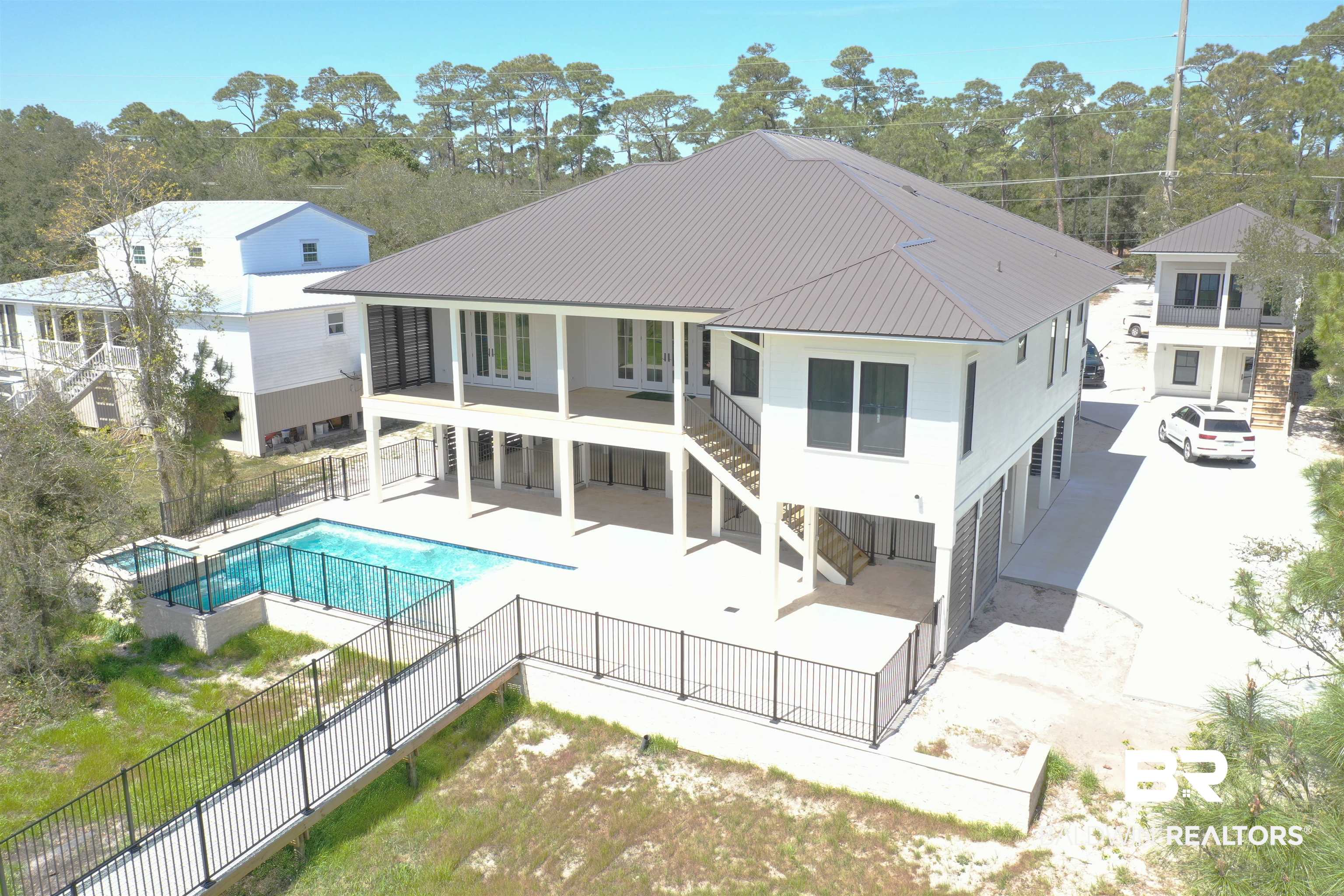 Discover unmatched sophistication & luxury in this, custom residence located on the tranquil shores of Little Lagoon. Positioned near the exclusive Peninsula Golf Club entrance, this Lagoon Front Estate promises an elite living experience with its striking '30A style' architecture & superior finishes. Spanning 3,259 square feet, this majestic home offers four bedrooms, each paired with its own bathroom, promising utmost privacy & comfort. An additional office, separate study & an expansive 1,036 sqft of porch space provide an abundance of room for relaxation. This estate is destined to be a landmark on Little Lagoon, featuring not only a main residence but also an impressive carriage house. This annex includes a 570 sqft guest suite or mother-in-law living space, located above a spacious 2-car garage. The grand entrance of the main house, accented by an elegant wide staircase, welcomes you to a world where modern functionality meets Southern charm. The interior is designed to impress with 10' ceilings, granite counters, tiled showers, solid hardwood floors. Experience culinary excellence in the gourmet kitchen equipped with a GE Profile appliances including 36" range, and a secondary pantry refrigerator. Spectacular views of Little Lagoon can be enjoyed from the primary bedroom, dining room, & kitchen, enhancing everyday living. The outdoor entertainment area includes a Gunite pool & hot tub, a grilling area, and a covered dock with boatlift, emphasizing a lifestyle of luxury and leisure. Includes private elevator. For those seeking an even more tailored living experience. This property promises a prestigious waterfront lifestyle & also offers a rare opportunity to own 1 of the most sought-after residences on Little Lagoon. $50,000.00 furniture / decorating allowance. An investment in this home is an investment in unparalleled luxury.  Buyer to verify all information during due diligence.