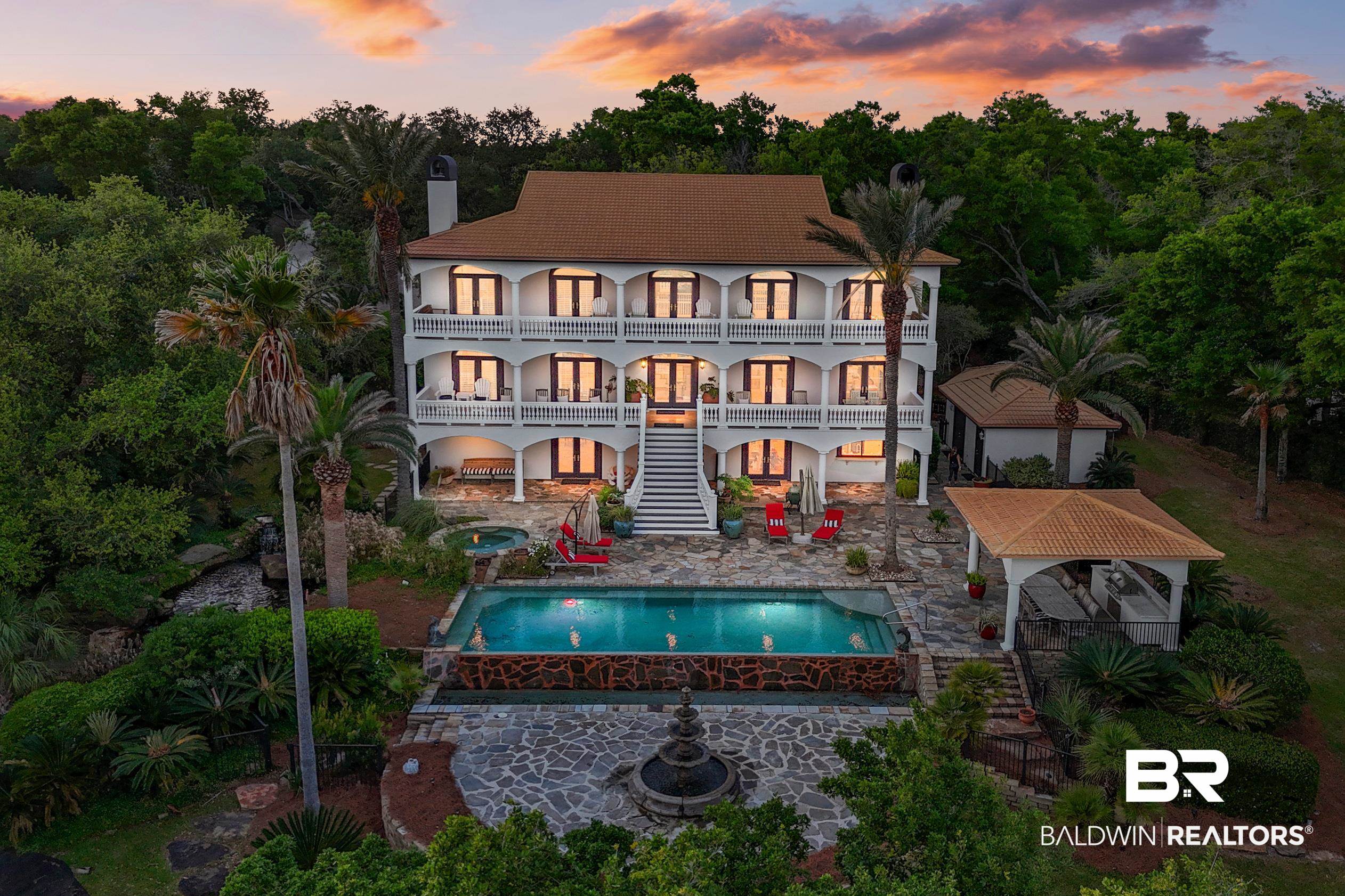 Experience unparalleled luxury and privacy with 136 feet of prime waterfront along Bayou St. John in the prestigious Orange Beach, Alabama. This remarkable estate stands alone in grandeur and design, welcoming you with a stately brick driveway lined by historic 1920s street lamps. The estate's lush landscaping and multiple garden areas amplify its Mediterranean allure. Spanning over 5,214 square feet of refined elegance, this home features over 4,000 square feet of expansive balconies across three levels, offering sweeping views and outdoor living. As you ascend the grand staircase, the entryway unfolds into an open, sophisticated layout where each detail is meticulously crafted—from the custom faux-painted finishes and bamboo flooring to the custom lighting perfect for art displays. The heart of this home is found on the second level, featuring the main living spaces with stunning views. The primary suite is a sanctuary of peace, equipped with a sitting area, fireplace, and a spa-like bathroom with ambient lighting, exquisite marble finishes, and a steam shower. The suite's walk-in closet is expertly fitted with custom storage solutions for ultimate organization. The third floor hosts two generously sized bedrooms, each with private bathrooms, and a large common area designed as a gallery space, ideal for art enthusiasts and hosting gatherings, offering a bird's eye view of the bay.The ground level serves as a versatile in-law suite or private guest space, complete with its own entrance, fully equipped kitchen, spacious dining and living areas, a laundry room, ample storage, and direct elevator access to the main level.Outside, the estate features quarry-stone decking, a saltwater pool with an infinity edge, a spillover spa, and a pool house with a full bath.Boating enthusiasts will love the deep water and access to Gulf of Mexico.This extraordinary property encapsulates the essence of luxury waterfront living, making it an unmatched retreat for discerning buyers.