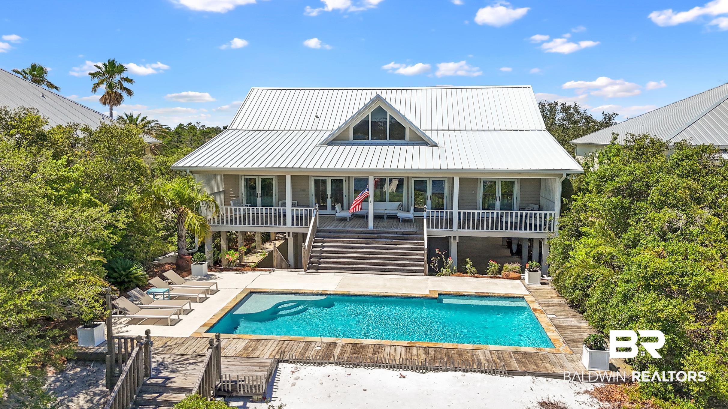 Nestled along the shores of Old River, this 5-bedroom, 5-bath home offers you the ultimate waterfront lifestyle with privacy and elevated, sweeping views. Showcasing wide open living space, stretched across 3,000 sf, this property is perfect for entertaining with room for all. The home has 4 en suite bedrooms on the main level and another convenient guest suite on the lower level, for privacy for all!  The great room and south bedrooms have direct access to the expansive covered porch with full views of the pool, sandy beach, boathouse and river. Escape to your private outdoor haven! The grounds offer over 1 acre of seclusion perched above sandy dunes with swaying palms, a sparkling pool and views of the river bursting with color at sunrise and sunset - your personal retreat for sun-soaked afternoons or intimate evening gatherings under the stars. The new boat house is top of the line with flow through decking and 16,000 lb lift accommodating up to a 36' boat. The home is equipped with a whole home generator, surround sound speaker system, fortified metal roof and so much more! Don't miss out on your chance to snag this slice of paradise!