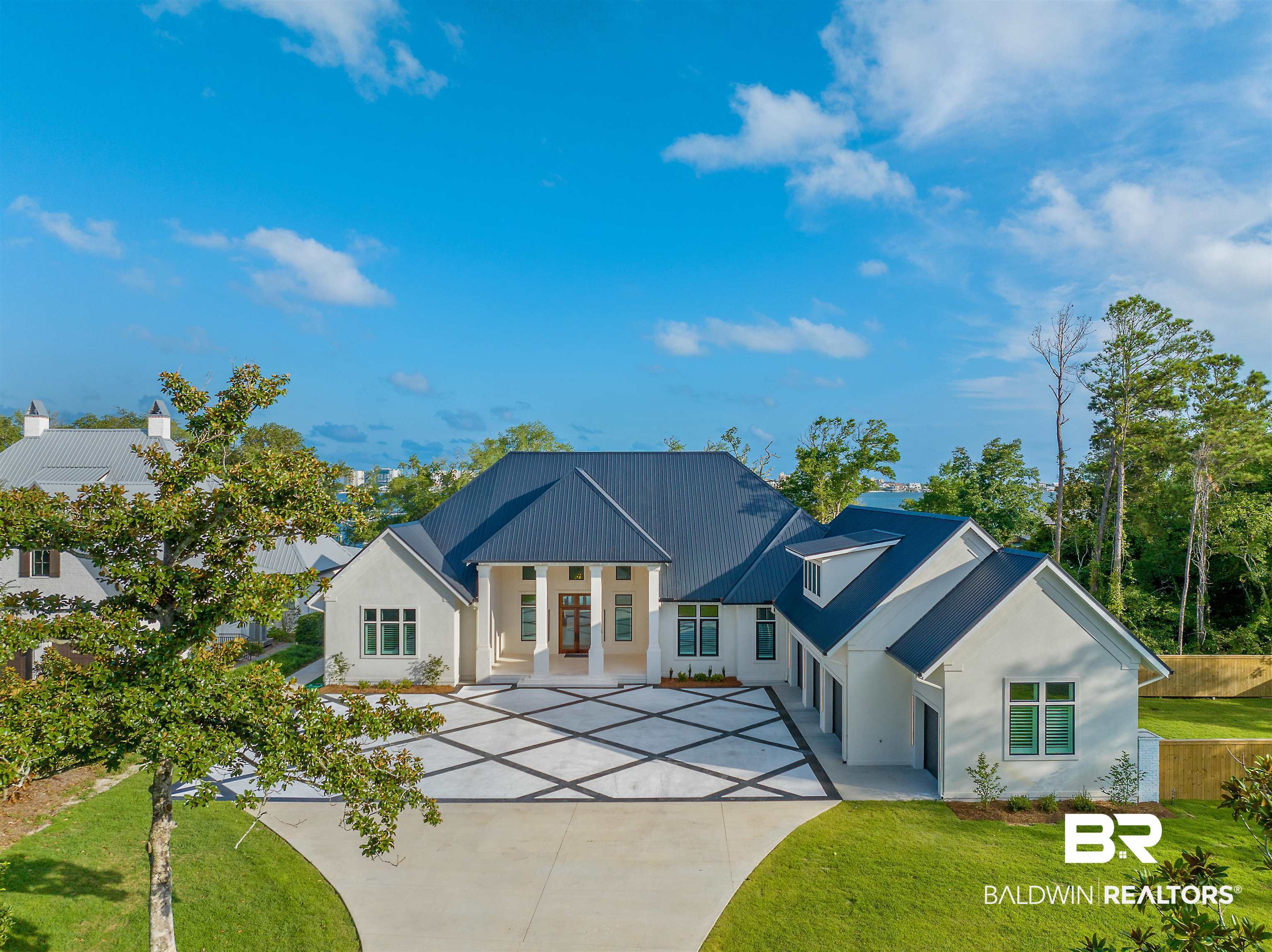 Experience luxury in this over 11,000sqft under roof insulated concrete form (ICF) home with 139ft  of shorefront access in a NO FLOOD zone on 3.3 acres in Orange Beach, AL. Designed by Bob Chatham, this Gold Fortified concrete slab home impresses with 12–18ft ceilings, cypress beams, Oak floors, all marble counters, hurricane grade windows, transoms, sliders, and unbelievable views of St John’s Bay. The kitchen and pantry have room for entertaining with custom floor to 12ft ceiling cabinetry, a 12ft marble waterfall island, a 60inch dual fuel Viking range, 2 paneled dishwashers, and 3 sinks. The primary bedroom showcases an 18ft sloped ceiling and a bathroom with a large marble slab walled shower with Brizo and Emtek fixtures and an oversized soaking tub. The sizable primary closet has floor to 12ft ceiling custom cabinetry with mirrors and a marble island that compliments the bathroom. Enjoy 2251sqft of covered outdoor space with 6 roll-down garage doors, a kitchen, and fireplace. All outdoor counters and fireplace hearth are covered with Taj Mahal marble. Jump in the heated pool or hot tub with both gas and electric heating options. Watch dolphins, manatees, and stingrays swim right below your feet on the expansive boat dock that was built with square pilings and sure step decking to withstand  higher grade hurricanes. Additional highlights include a 1665sqft garage, bonus room and full bath, laundry with dual washer/dryer sets, a large pet wash station with Zellige tile, and a massive walk in attic with 12-15ft ceilings. An industrial grade drainage system has been installed throughout the property along with a 38kW Generac generator with a 500 gallon propane tank. Combining luxury, comfort, and safety, this estate offers the ultimate coastal lifestyle and true protection from extreme weather. Buyers to verify all information during due diligence. Buyer to verify all information during due diligence.