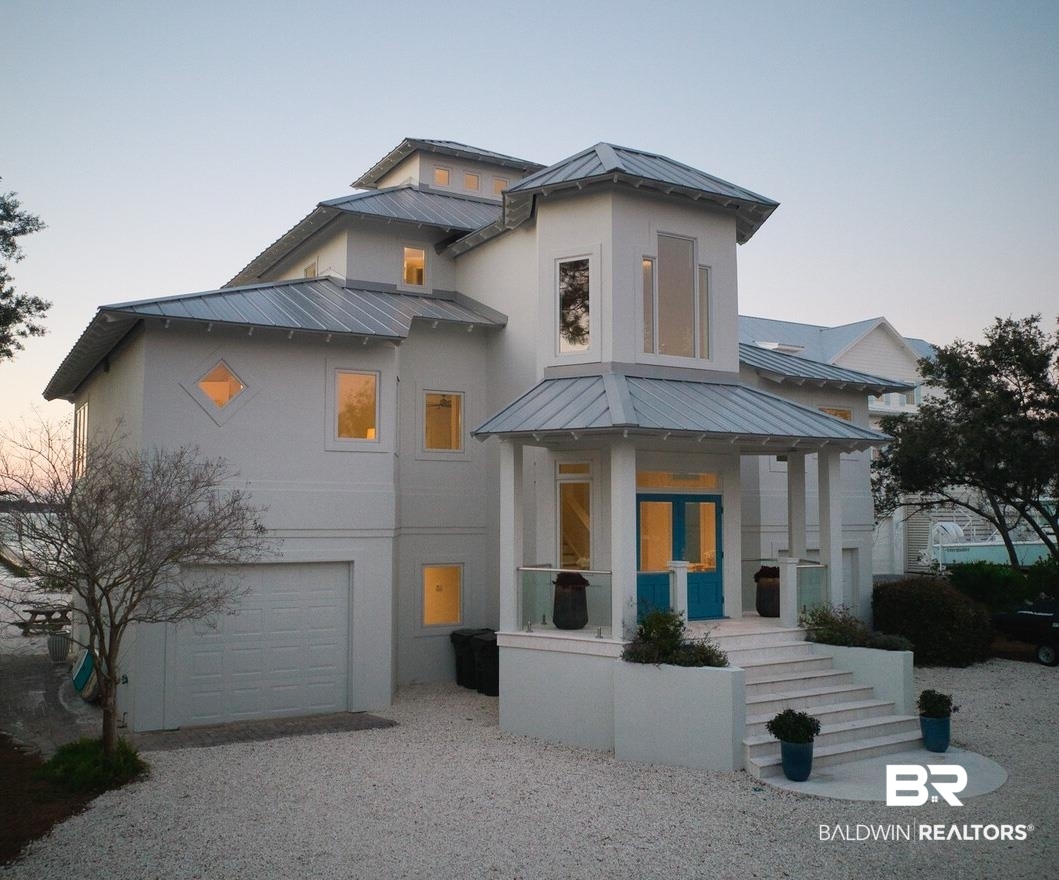 This gorgeous waterfront home is often admired as one of the nicest lots on the island.  Boasting an ideal location, the property features a large private beach on 135’ of waterfront footage and a pier leading to a 2 slip covered dock (with newer boat lifts ) that extends to unobstructed views of the water.  This perfect waterfront refuge offers breathtaking views of the Bayou St. John, magnificent sunsets, and frequent dolphin sightings, enhancing its mesmerizing beauty.   Enjoy hours of relaxation in this tranquil, peaceful setting, making unforgettable memories.This stunning 3 story home includes a private owner’s suite on the third level with a private balcony.  The spacious and open living area is perfect for gatherings, and the gourmet chef’s kitchen equipped with Wolfe gas range, ice maker, bar sink, and wine refrigerator, is ideal for entertaining.  Large picture windows provide sweeping views of the water.  Additional features include a large covered patio, a spacious screened porch, and an outdoor shower.  Located on a cul-de-sac, this home offers both privacy and a sense of community. Buyer to verify all information during due diligence.