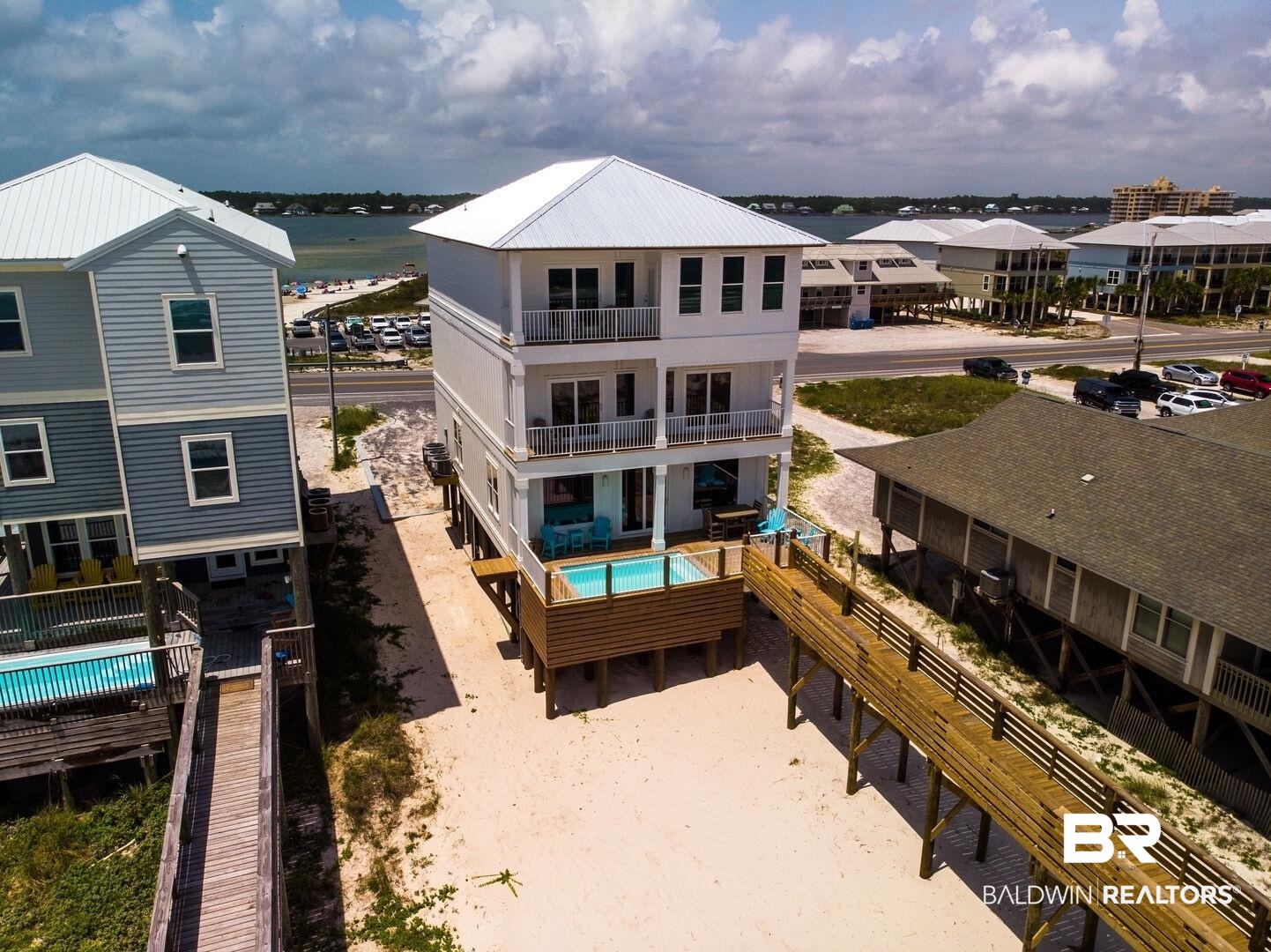Experience luxury beachfront at its finest with this stunning first-tier Gulf-front beach house in Gulf Shores, Alabama, located on West Beach Blvd just across the street from Lagoon Pass Park. Offering breathtaking views of both the Gulf of Mexico and Lagoon Pass, this property presents a rare opportunity to own a vacation rental gem. Built in 2019 and boasting Gold Certification, this spacious retreat features 8 bedrooms, 8.5 baths, and comfortably sleeps up to 22 guests, making it an ideal investment property. With impressive rental incomes of $352,000 in 2022 and $319,000 in 2023, along with bookings already exceeding $253,000 for 2024, this property is a proven money-maker. Enjoy private leisure with a heated saltwater pool and a private elevated boardwalk leading directly to the beach. The convenience of an elevator enhances accessibility throughout the home. Inside, the oversized living room offers multiple seating and dining areas, perfect for entertaining. The kitchen is equipped with double refrigerators, double dishwashers, a large commercial-size oven, and an icemaker, catering to all culinary needs. Additionally, an upper-level den with kitchenette has a coffee bar and beverage fridge for added convenience. Spacious bedrooms, each with its own private bath with Gulf and Lagoon views. Guests of the "Out of the Blue" house delight in returning year after year for unparalleled comfort and luxury of Gulf-front living. Don't miss out on the opportunity to own this exceptional beachfront oasis in Gulf Shores, Alabama. Buyer to verify all information during due diligence.