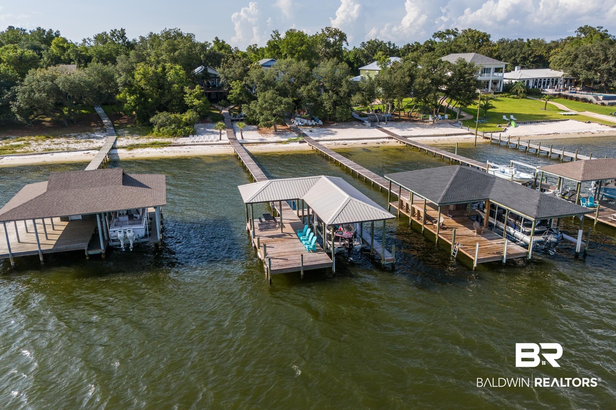 Welcome to your waterfront oasis in Orange Beach, AL!  Nestled on a sprawling 1.05-acre lot along the picturesque Bayou St. John, this stunning 6-bedroom, 5-bathroom retreat offers the ultimate coastal lifestyle. From its private beach, pier, and boat house to its three serene outdoor seating areas, this property is designed for relaxation and entertainment. Spanning 3,254 square feet, the home has been extensively renovated, blending modern luxury with timeless charm. In 2020, two bedrooms and two bathrooms were added, along with a new Trex staircase and porch, complete with a lift. The main floor now boasts 5 bedrooms, 4 bathrooms, a spacious living room, a chef’s dream kitchen, and a convenient laundry room, all adorned with luxury vinyl plank flooring throughout.The gourmet kitchen is truly the heart of this home, featuring an abundance of custom cabinetry, a stunning quartz island, a chic tile backsplash, and ample seating space. Equipped with top-of-the-line stainless steel appliances, a gas range, wet bar with a wine refrigerator and ice maker, this kitchen is perfect for entertaining. A new metal roof was installed during the renovation, along with an extended, water-facing deck that provides breathtaking views and quick access to the beach and pier via a newly constructed staircase. The lower level offers a private bedroom and bathroom, a game room, second laundry room, and a versatile office space that doubles as storage. Two additional storage rooms provide easy access to water toys and yard equipment. This property features modern upgrades, including two new HVAC systems (2021) and a tankless electric water heater (2021). The pier is a boater's dream, complete with covered decking, a 16,000 lb boat lift with a new motor (2021), power, and water. The pier and boathouse decking were replaced in 2021. Minutes from the islands and Gulf, an opportunity you do not want to miss! Buyer to verify all information during due diligence.