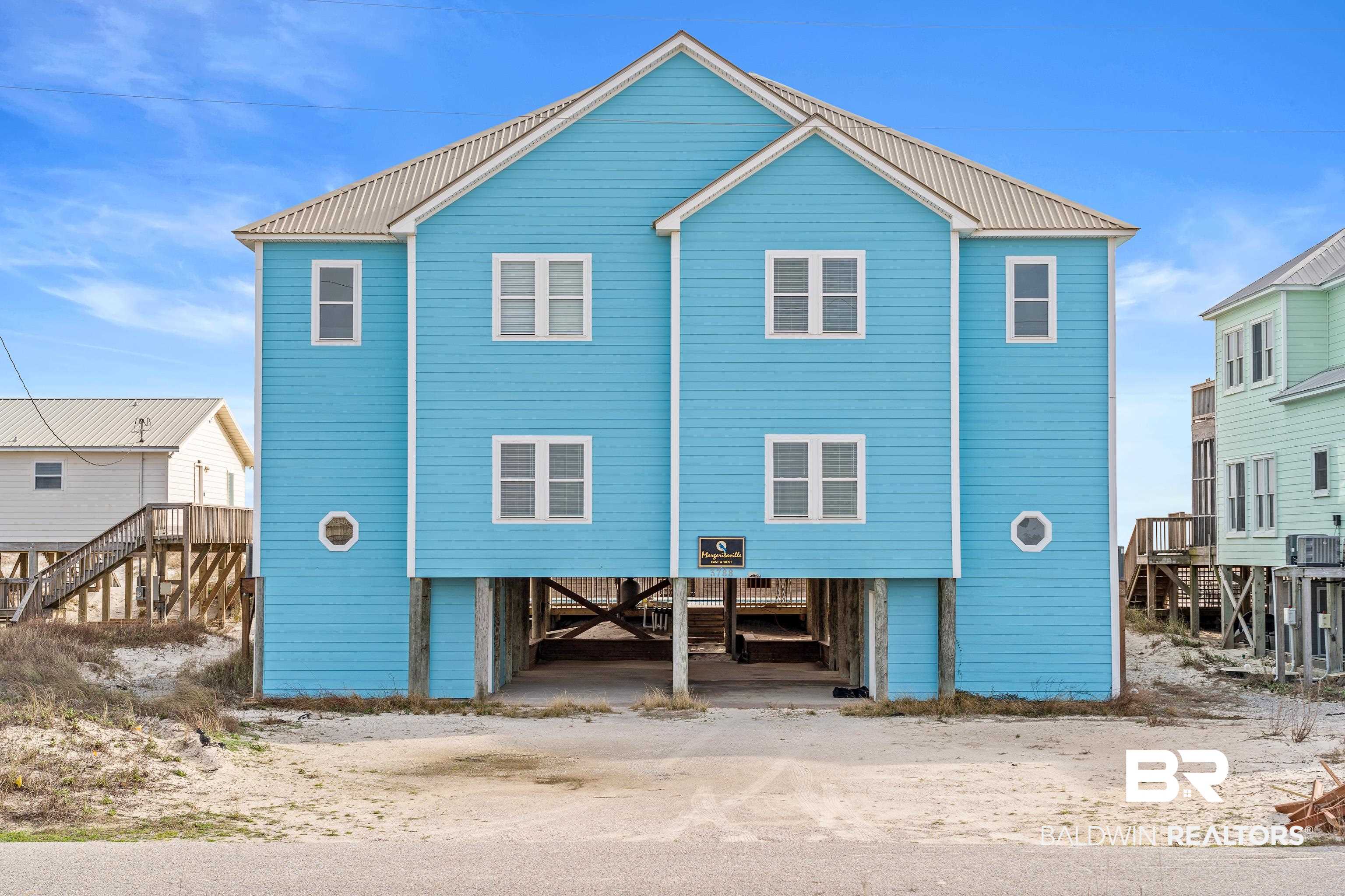 The epitome of coastal living awaits at this professionally decorated Gulf-front duplex in Fort Morgan—complete with a newly installed pool and composite deck in 2024. When you’re not soaking up the sun on the sugar-white beach or unwinding by the new pool, immerse yourself in the endless Gulf views and gentle sea breezes. Each side of this duplex offers 6 bedrooms and 4.5 bathrooms, providing incredible flexibility for large gatherings or lucrative rental opportunities—rent both sides, or keep one for personal use. You’ll be just minutes from exploring the historic Fort Morgan State Historic Site, teeing off at Kiva Dunes Golf Course, and savoring local flavors at Jesse’s on the Bay. Inside, the open and bright living area showcases wood floors and generous windows that let natural light pour in while framing breathtaking beach views. Chefs will appreciate the kitchen featuring stainless steel appliances, two dishwashers, a double oven, quartz countertops with quartz backsplash, bar seating, and a wet bar with an ice maker—perfect for entertaining. The first-floor bedroom boasts an en-suite bathroom, and there’s also a convenient half bath on this level. Upstairs, a bonus space awaits—ideal for a reading nook, game corner, or cozy sitting area—along with two Gulf-view bedrooms opening to a shared balcony, one of which is a master suite with its own en-suite bath. Step outside from the main level living area to enjoy a covered porch with a privacy wall, then wander down to the pool or head straight to the beach via the boardwalk. Rinse off in the convenient outdoor shower before heading back inside. Underneath the home you will find ample parking and a handy cargo lift, making unloading groceries and luggage a breeze. This property can be an idyllic getaway or a prime investment with tremendous rental projections of $182k for each side! East and West units can also be purchased separately (MLS# 380606 & MLS# 380608). Buyer to verify all information during due dilige