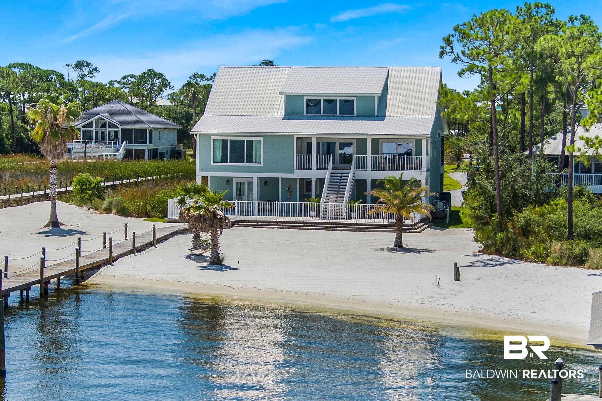 Luxury Waterfront Living on Ono Island. Perfectly positioned along the pristine shores of Bayou St. John, this exceptional 6-bedroom, 4-bathroom custom-built home is a rare opportunity to own a fully renovated estate on one of the most sought-after streets on Ono Island. Blending timeless elegance with serene coastal charm, every detail of this 1.31-acre property has been thoughtfully designed to offer the ultimate luxury and comfort. Step inside to discover sweeping water views from every room, complemented by refined finishes and a seamless open layout. The gourmet kitchen is a chef’s dream, featuring high-end stainless-steel appliances, striking quartz countertops, and ample space for entertaining. The spacious primary suite offers stunning waterfront vistas, custom window treatments, and a spa-like ensuite with a soaker tub, smart mirror, electric blinds, and a custom walk-in closet. Upstairs, two bedrooms, walk-in closets & a generous loft create the perfect setting for family living or a flexible office space. The ground level includes a fully equipped private guest suite with its kitchen, laundry, and living quarters—ideal for visitors or extended stays. Step outside to your private paradise, with a sparkling saltwater Gunite pool surrounded by Kool-Crete and an impressive covered boat dock featuring a 12,000lb lift, wet slip, outdoor cooking station, sink, gas range, two TVs, and a rooftop lounge deck. Just beyond, relax on your white sand beach with panoramic water views. The beautifully landscaped grounds are enhanced by lush Zoysia grass, a separate irrigation well, palm trees with bubbler & uplighting & a gated driveway that welcomes you home. All 1.31ac are fully usable, creating an expansive, resort-style setting. Additional highlights include a Dover elevator servicing the ground and main floors, gas plumbing & access to exclusive Ono Island amenities, including 24-hour security, a playground, and boat launch. Buyer to verify all information. Buyer to