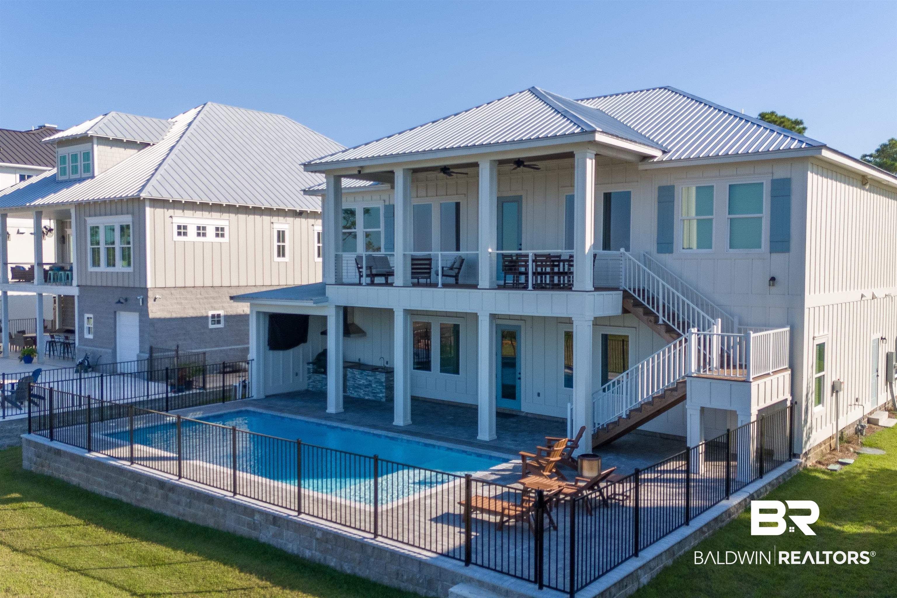 Discover bayfront living in this 7 bedroom, 7 bathroom home in Orange Beach, located conveniently close to schools, recreation center, tennis courts, library, Coastal Art Center and the beautiful Waterfront Park. Golf cart to your favorite restaurants, hop on your bike and enjoy the Hugh Branyon Backcountry Trails, or take a relaxing boat ride. If fishing is what you are into, you can enjoy the beautiful back bays or be in the Gulf in about 15 mintues. This home was constructed to GOLD FORTIFIED standards and offers 2x6 exterior walls, a metal roof, hardie board exterior, and composite decking, all with seller paying as little as $3100/yr for insurance. The kitchen features Café Appliances, a dual fuel range, quartz countertops, and custom cabinetry, making it ideal for cooking enthusiasts. High ceilings and white oak LVP flooring enhance the spacious interior. Downstairs could be it's own oasis, offering 3 bedrooms, 2 bathrooms, full kitchen and its own laundry room. The property includes an office space for remote work, a dedicated gaming room equipped with 4 flatscreen TVs, and an elevator ready shaft framed and prewired. Additional highlights include a prewired 2-car garage for electric vehicle chargers and a commercial ice machine. Outdoor features include a saltwater pool, an outdoor cooking area, an outdoor shower, Sure-Step decking over the water, a 13,000 lb boat lift, two wave runner lifts, and parking for up to 10 vehicles. Tech amenities include WiFi garage door openers with cameras and 1 Gigabit fiber internet. This property offers a blend of modern convenience and coastal charm, with no HOA fees and a Zone X Flood designation (flood insurance not required). Check out our visual tour! Buyer to verify all information during due diligence.