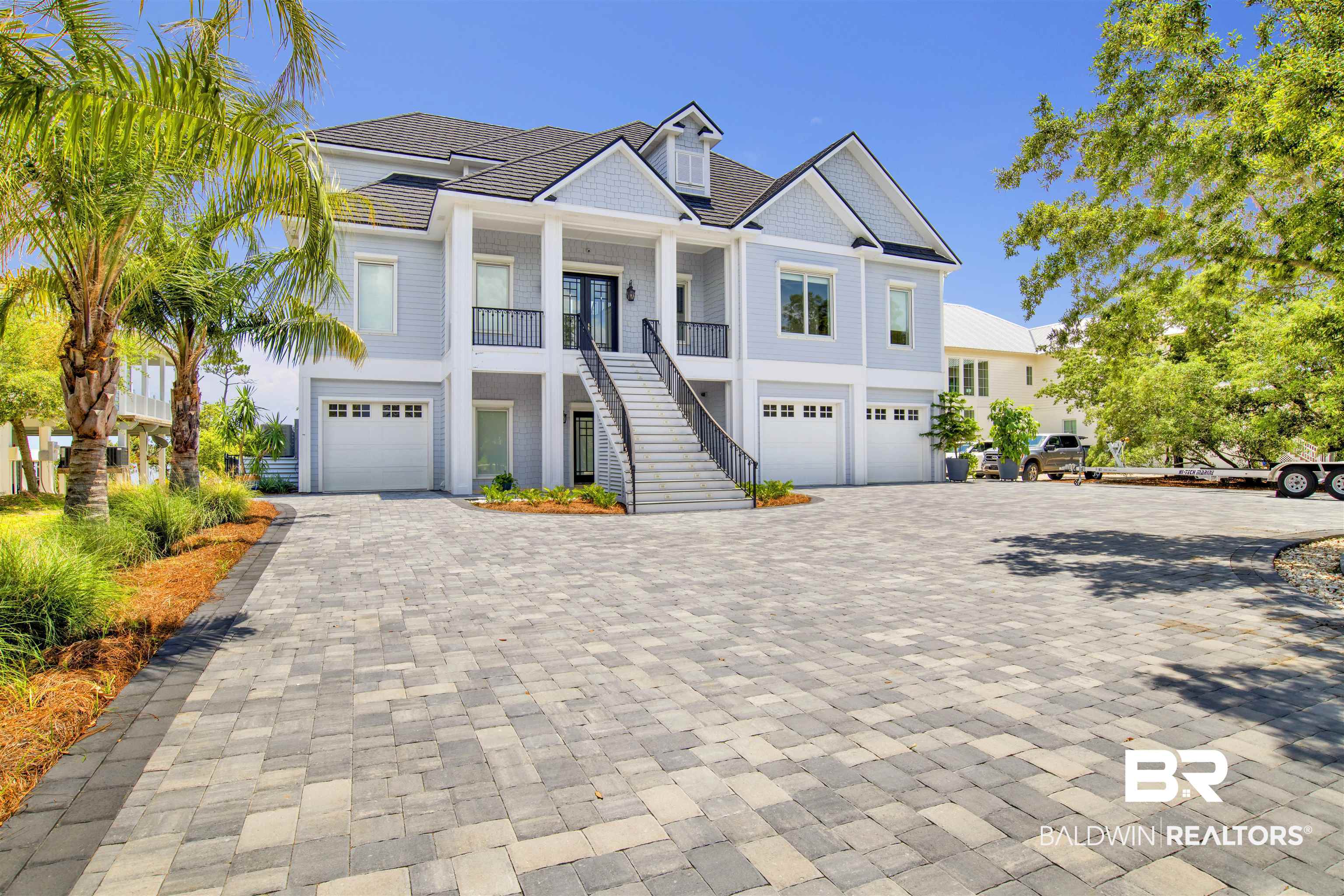 Just minutes from the Pass and white sandy beaches, this beautifully maintained stunning Ono Island waterfront property offers a plethora of amenities including a saltwater gunite infinity POOL, private dock with spacious BOATHOUSE, extensive terraces, two kitchens, two laundry rooms, five private generous bedroom suites situated in a picturesque setting with panoramic southern views of Old River, Florida's Perdido Key State Park and the Gulf of America. The main level includes a grand foyer, magnificent sunlit great room, dining room and kitchen including pantry with top-of-the-line appliances, an elegant waterfront primary suite with dual walk-in closets along with a private guest suite, powder room and laundry room. The first level features a fully self-contained waterfront one-bedroom apartment with private entrance, 13' x 9' storage including two garages (25' x 33'/29' x 10') with heavy-gauge New Age garage storage cabinetry or ascend to the third level by ELEVATOR to discover two generous private waterfront bedroom suites complete with a loft, private office space and large 18' x 19' floored attic. Nearly every space is graced with panoramic water views. Property is truly spectacular. Schedule your private viewing today and capture the spirit of the Ono Island lifestyle. Buyer to verify all information during due diligence.