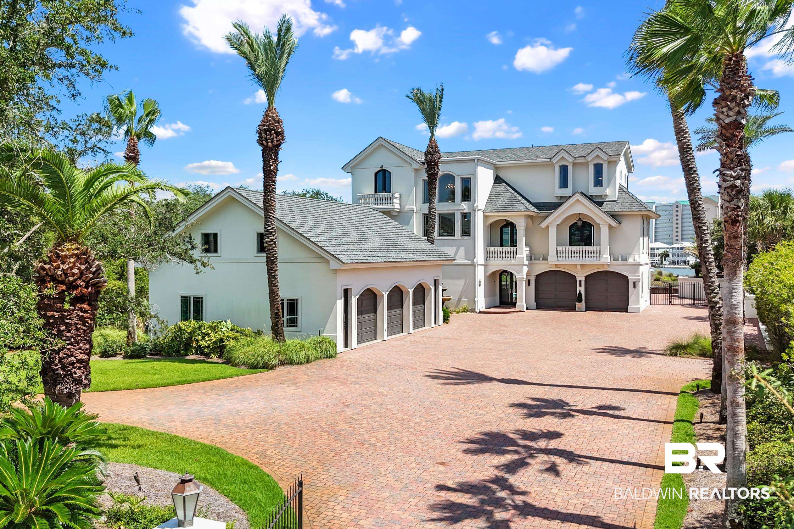 Welcome to this exquisite Mediterranean style waterfront retreat on Ono Island, offering 100 feet of prime waterfront on Old River, less than a mile from the Ono bridge! Designed for luxury and built to last, this ICF concrete construction masterpiece features high end stainless appliances, a gas fireplace, impact windows and doors, tankless water heater, private elevator, TWO laundry rooms, a fantastic rec room complete with a bar and a billiard table and a card table, a butler’s pantry & wet bar, beautiful furnishings by Cindy Meador Interiors, an outdoor kitchen with gas grill, beautiful pool, boat house with 2 boat lifts, and 100’ of private white sandy beach on Old River. The huge primary suite features a large sitting area, large custom closet, two water closets and a bidet, a soaking tub, and gorgeous water views. In addition to the 6,100 square feet of living space, there is a detached heated and cooled 3-CAR GARAGE that has plenty of room for all of your toys, custom cabinets, a full bathroom, and a large loft area that would be great for a man cave or media room. There is over 2,300 sq ft of covered porches and patios, and a tiki hut that are all ideal for sunset cocktails, weekend barbecues, or morning coffee. Enjoy incredible views of Old River, the Gulf, and Bayou St John. With it’s gated driveway and mature landscaping, this property offers so much privacy. The roof on the home and boat house were replaced in 2020/2021. The exterior was painted and resealed, and new impact exterior doors were installed in 2022. Home sits in X Zone! Home conveys furnished. Ono Island is a premier residential island community with a guarded entrance that provides privacy and security for its residents. Community amenities include a fitness center, indoor & outdoor pool, tennis & pickleball courts, playground, boat launch, and 24-hour security! Buyer to verify all information during due diligence. Be sure to watch the virtual tour.