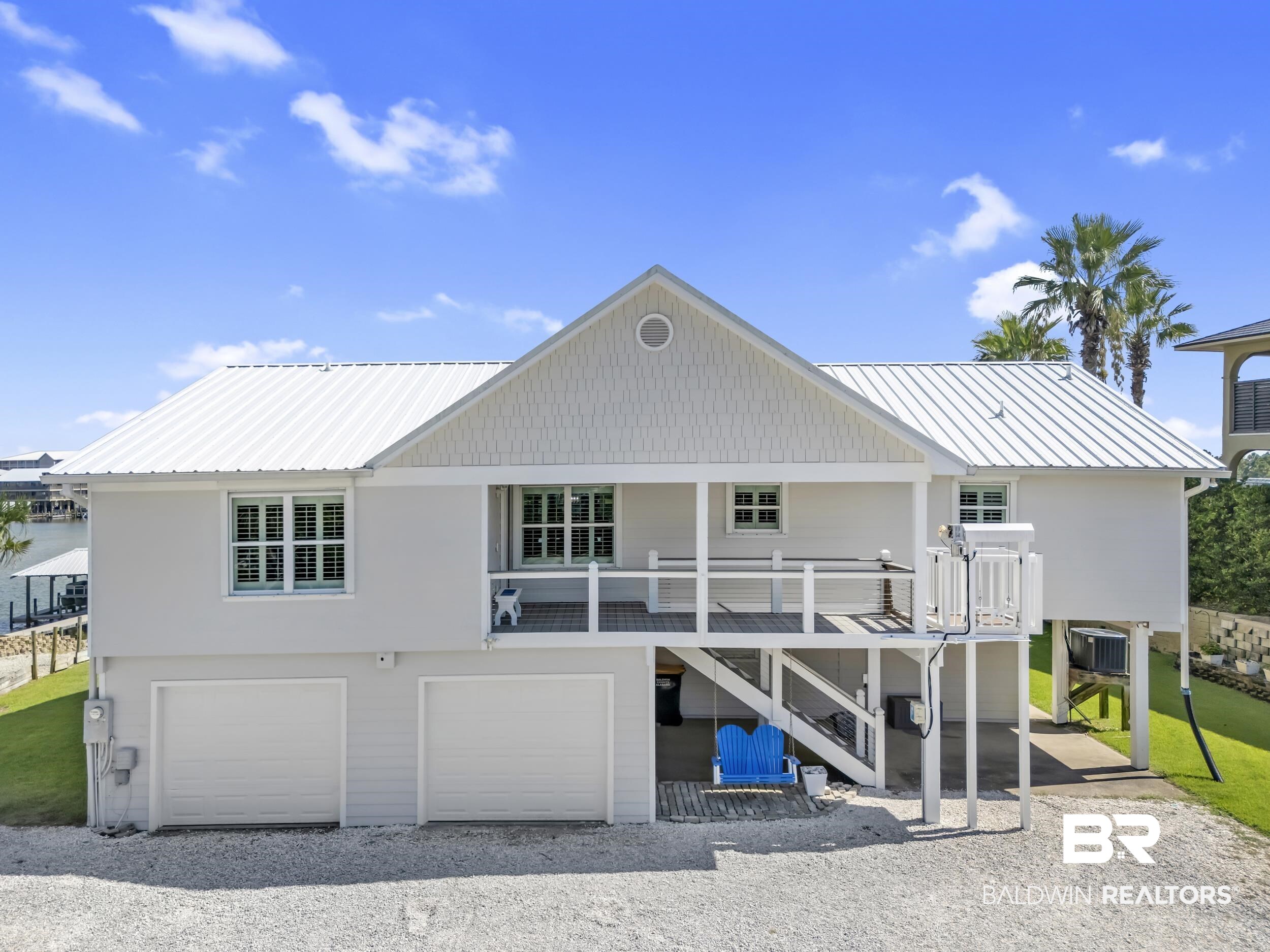 This is a coastal retreat perfectly situated just moments from the Ono Bridge. This 3-bedroom, 3.5-bathroom home blends comfort and functionality with island living. Inside, you’ll find tile flooring and a vaulted ceiling in the living room that fills the space with natural light. The deep garage provides ample storage, while the tackle room—complete with a bar, half bath, and mini split—offers the ultimate setup for entertaining after a day on the water.Enjoy the sparkling saltwater pool, relax on the private beach area, or take advantage of the boathouse with two lifts—ideal for all your boating adventures. An outdoor elevator adds extra convenience, and the expansive driveway ensures plenty of parking for guests. Whether you’re hosting gatherings or enjoying peaceful evenings by the water, this property has it all. Come experience why this home is truly Ono Island living at its best! Buyer to verify all information during due diligence.