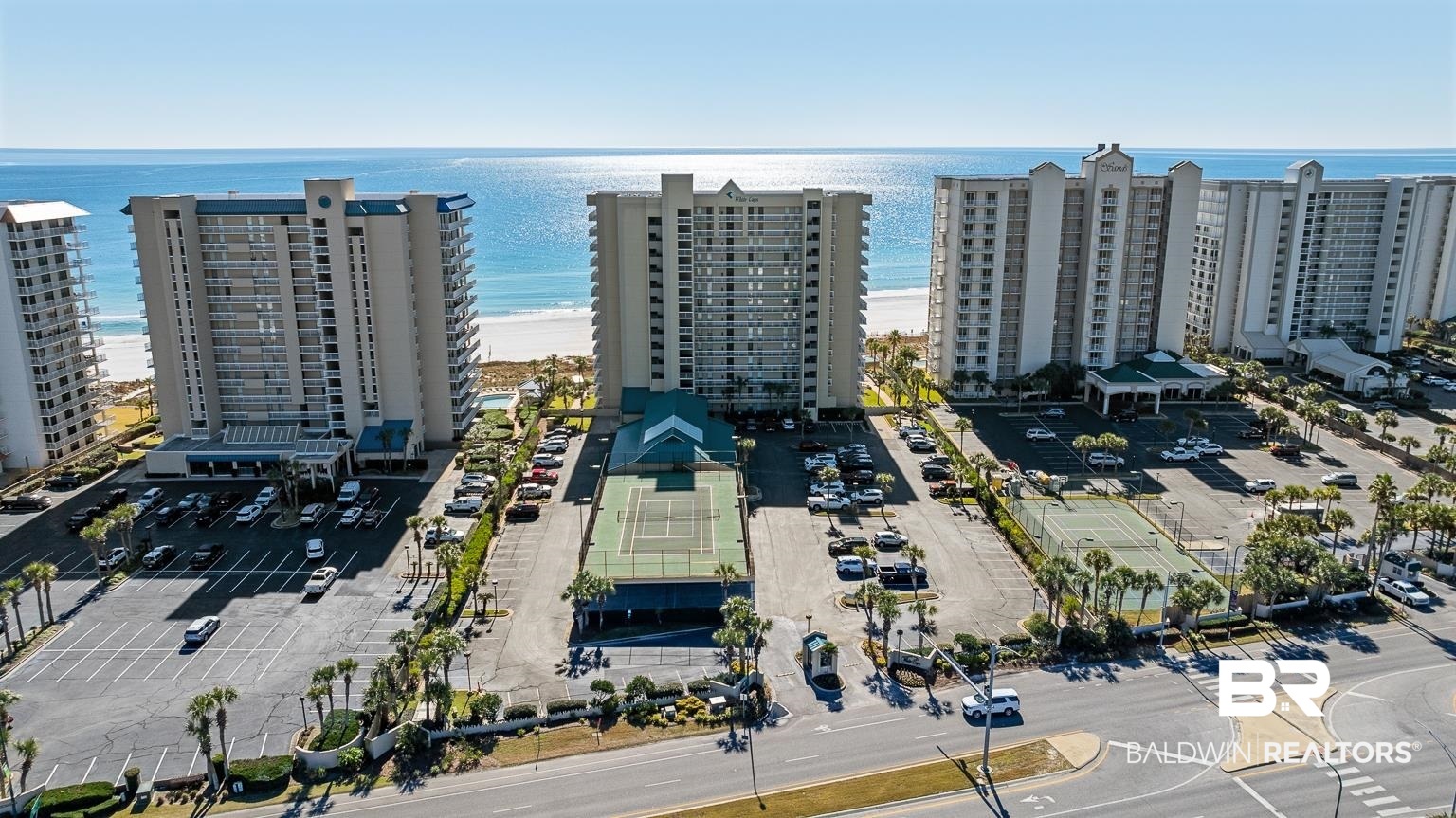Gulf views for miles! White Caps 601 is a rare east-corner residence offering expansive, unobstructed Gulf views that surpass those of surrounding buildings, thanks to its commanding beachfront orientation that delivers a wider shoreline perspective than its neighbors. Updated floor-to-ceiling sliding doors and windows fill the living space with southern light and open to a deep, deluxe balcony with wraparound side balcony, providing ample outdoor living and entertaining space. The kitchen was reimagined in 2021 with updated cabinetry, Fantasy Brown countertops and island, and stainless steel appliances, then was enhanced in 2022 with a custom built-in coffee bar with a beverage fridge and additional storage. Interior updates continue throughout the fully furnished, rent-ready condo with many new contemporary furnishings and artwork added in 2022, all thoughtful design choices that balance style and durability. Guest bedrooms feature brand new LVP flooring installed in 2025, complemented by new interior doors for a cohesive finish. Major upgrades offer long-term peace of mind, including impact-resistant doors added in 2021, electric storm shutters on all doors and windows in 2022, a new water heater in 2024, and a brand new HVAC system in the fall of 2025. An owner’s closet off the balcony includes a second refrigerator, a unique and functional feature for beachfront living. The corner layout enhances privacy, maximizes cross-breezes and panoramic views, and allows for blissful outdoor enjoyment, thanks to the generous balcony. This Orange Beach residence blends stylish finishes, smart upgrades, and a layout that embraces the natural beauty of the coast. With a strong rental history and amenities that support year-round demand, including a heated indoor pool and hot tub, a Gulf-front outdoor pool, a kiddie pool, tennis and pickleball courts, gated entry, and covered owner parking, White Caps remains a consistently high-performing Gulf-front property in Orange Beach.