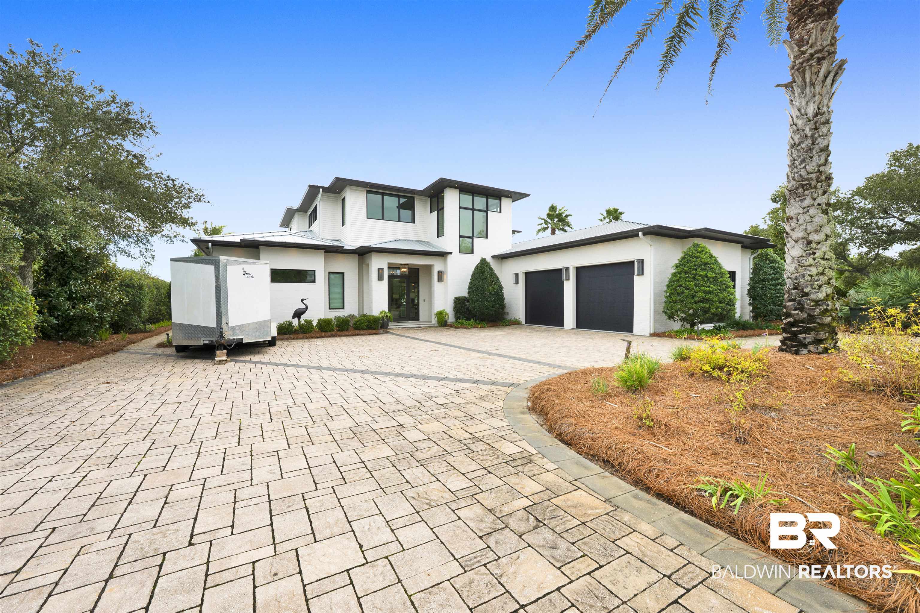 Experience coastal living at 29712 Ono Blvd, a waterfront residence located on Old River with approximately 100 feet of deep-water frontage on Ono Island. The property offers convenient access to the Gulf and features a covered private boat dock with dual boat lifts and jet ski lifts. The outdoor living area includes a covered entertaining space, outdoor kitchen, and ventless gas fireplace. Interior features include wood and tile flooring, custom cabinetry, stone accents, designer lighting, and stone countertops throughout. The gourmet kitchen is equipped with Wolf and Sub-Zero appliances. The primary bedroom suite includes a dual-entry stone shower, dual water closets with bidets, and abundant natural light. Additional features include expansive covered porches, a two-car garage, home generator, and indoor elevator. Buyer to verify all information during due diligence.