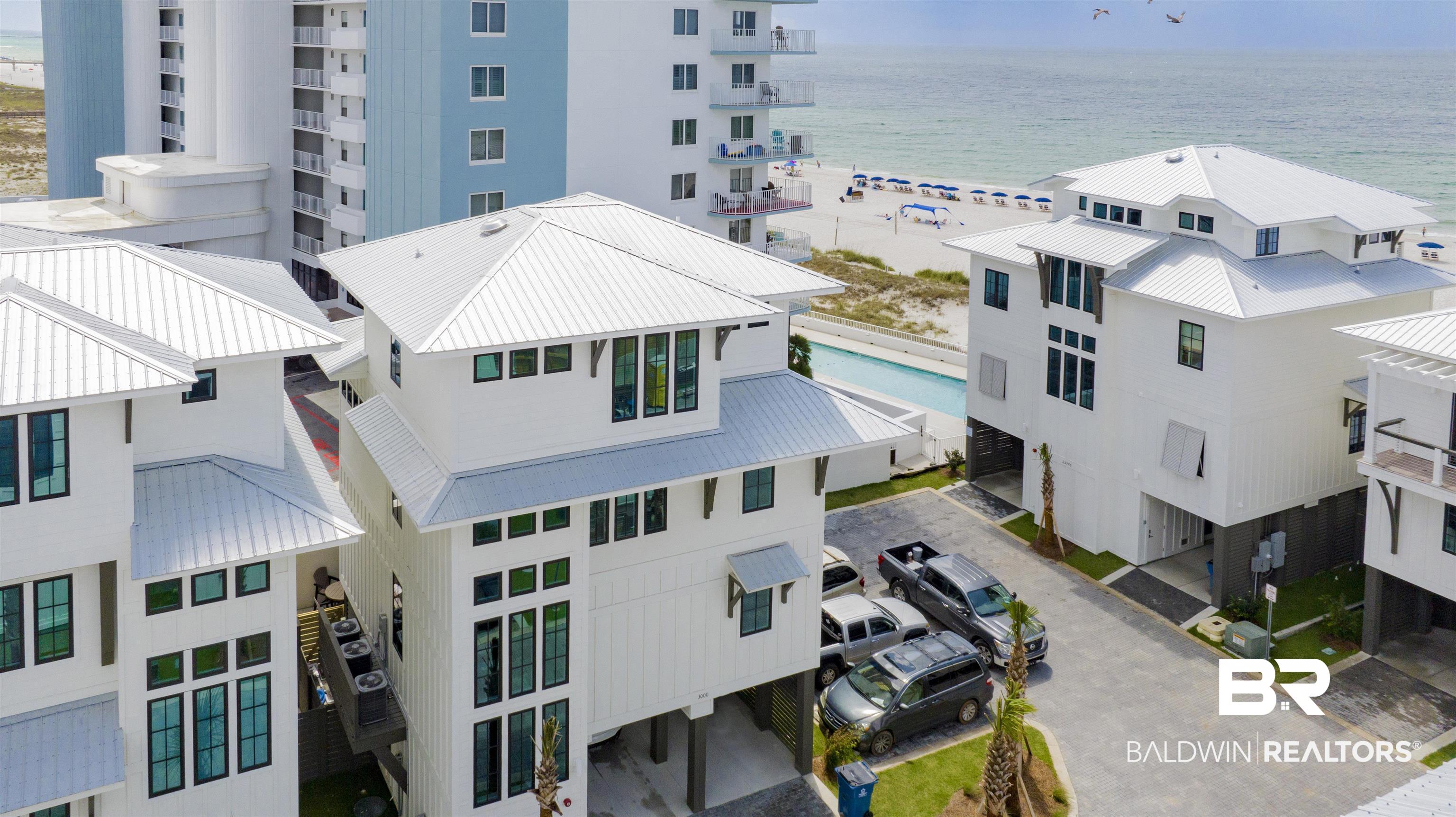 Welcome to your perfect Orange Beach getaway in The Bluffs! Newly completed in Spring 2023, this stunning 4BR/4.5BA luxury beach home offers the perfect blend of upscale comfort, coastal elegance, and unbeatable location. Thoughtfully designed with gorgeous finishes, abundant natural light, and Gulf views, this home was made for unforgettable family vacations. This beautifully appointed residence features a top-floor primary suite with a spa-inspired bath and private retreat feel, while every additional bedroom is a spacious king suite with its own private bath. Designed with both luxury and functionality in mind, the home offers wood flooring throughout, 10’ ceilings on the main living level, 9’ ceilings on bedroom levels, solid-core interior doors, impact-resistant windows and doors, fiber optic internet capability, and an elevator servicing all floors. The gourmet kitchen is truly a showpiece with a large island, quartz countertops, custom cabinetry, a pantry, and premium Wolf/Sub-Zero/Thermador appliances. Entertaining is effortless with the wet bar, beverage center, and ice maker, while the large utility/laundry room adds convenience for extended stays. Outdoor living is equally impressive with three spacious decks, Gulf breezes and views on every level, and a private heated gunite pool complete with lanai, fountains, grilling area, outdoor shower, and ample seating space for relaxing after a day at the beach. Multiple lockable storage closets provide additional convenience for beach gear and owner storage. Enjoy access to a community dune walk-over providing easy beach access. Perfectly located in the heart of Orange Beach, you’re within walking distance to shopping, dining, nightlife, and the area’s newest hot spot — COASTAL beachside bar and restaurant. 3-night minimum rental and sleeps 14 people. LOCATION, LOCATION, LOCATION!! Buyer to verify all information during due diligence.
