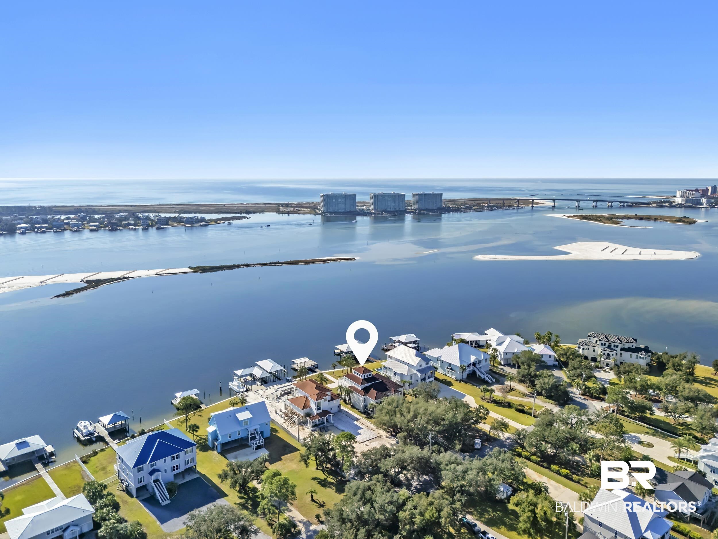 Very rare opportunity on deep, open water with easy access to Perdido Pass and the Gulf of Mexico! Seller will entertain Owner Financing.  Luxury abounds in this one-of-a-kind coastal retreat where no detail has been overlooked. This expansive 4-bedroom, 4-full and 2-half-bath home (potential for 5th bedroom) is set on a beautifully landscaped lot with approx. 90 ft of waterfront on Bayou St. John and features a new deep-water boat dock with slip. Enjoy real wood floors, custom crown molding, and a third-floor observation room offering 360° views of Terry Cove, Johnson Cove, and the Gulf. Impact windows and doors throughout. Spacious bedrooms include a private en-suite and balcony with stunning water views. The elegant wood-paneled elevator accommodates multiple passengers and is handicap accessible. A bonus room with vaulted wood ceiling and arched window enhances the coastal character. The chef’s kitchen boasts imported Brazilian white marble counters, under-counter wine cooler, abundant prep space, and breathtaking water views—ideal for gatherings or entertaining. The 3300 sq ft., 6-car heated and cooled garage offers epoxy floors, half bath, extensive storage, space for rod room, boats, and in-home gym. Step outside to enjoy waterfront activities, outdoor shower, and reinforced bulkhead. The first-floor primary suite features a Bain Swedish spa tub, multi-head shower with exceptional water pressure. Additional highlights include a formal dining room (or study), custom “Birds of Paradise” wrought iron staircase, central vac system, and dedicated laundry  and cleaning closet with utility sink. A true coastal masterpiece built for comfort, elegance, and the ultimate waterfront lifestyle. Buyer to verify all information during due diligence.
