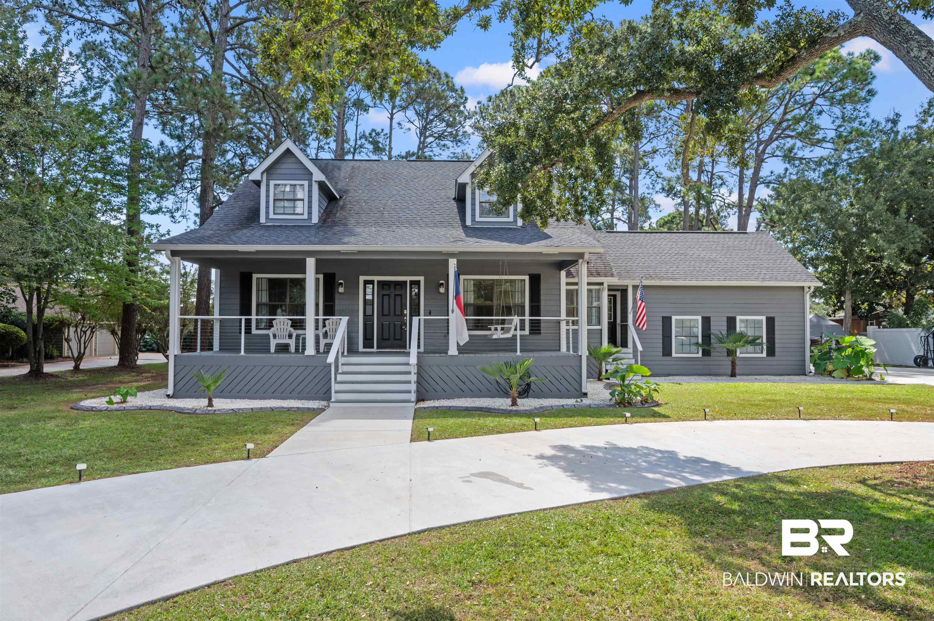 Welcome home to this beautifully updated 4-bedroom, 2.5-bath retreat in Wedgewood Estates, perfectly positioned on over half an acre with no HOA and a peaceful golf course backdrop. Just 2.5 miles from the sugar-white beaches of Gulf Shores and a short half-mile from the Bodenhamer Rec Center, this property offers convenience to parks, top-rated schools, the South Baldwin Community Theater, the public library, and many of the area’s favorite restaurants. This cedar-sided home has been thoughtfully improved inside and out, featuring granite countertops throughout, new vinyl flooring in all bedrooms and the secondary living area, soaring ceilings, and a striking wrought-iron staircase leading to a cozy loft. The kitchen is a true showpiece with stainless-steel appliances, a gas stove, subway tile backsplash, a custom island, and a breakfast nook with built-in bench seating and storage. The formal dining room and rustic barn doors add warmth and character, while the inviting living area with a fireplace and double French doors opens to a covered back porch overlooking the golf course. The primary suite on the main floor includes private porch access, a walk-in closet, double vanity, and a tiled tub/shower combo. Upstairs are three additional bedrooms and a full bath, one featuring a sitting area and extra storage. Major updates include a Bronze Fortified roof (2018), Rheem AC (2020), Rheem water heater (2024), and a Kohler 20kW natural gas generator with warranty through May 2028. Outside, enjoy a new concrete circle driveway, PEX plumbing, stamped concrete curbing, fresh paint, and a rebuilt porch with metal posts and stainless cabling. A paver patio with fire pit, side-entry garage, dual laundry hookups, and boat space complete this beautiful Gulf Shores property.