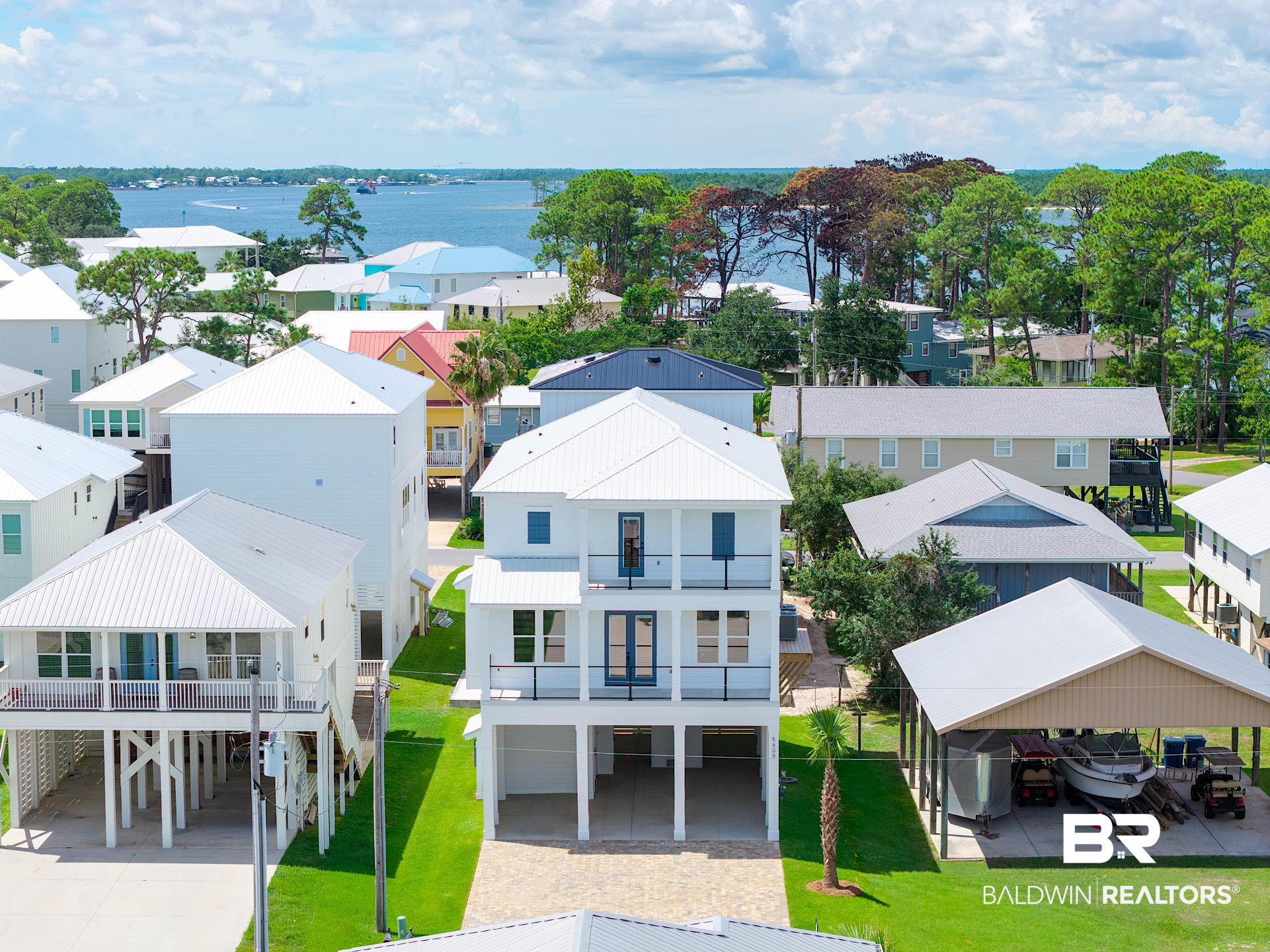 New construction, piling-elevated custom home — 2,809 sq ft, 4 en-suite bedrooms, elevator, and Gold Fortified construction in Bear Point Estates, Orange Beach, Alabama — Completed August 2026. Built by ARK Builders on an easy-maintenance level lot, this 4-bedroom, 4-bathroom residence delivers the resilience and finish level serious coastal buyers require: Gold Fortified certification, impact storm windows, whole-home generator, engineered pilings, and tankless water heater. The open ground level provides covered parking, storage, and entertaining space beneath the home. The main living level features an open-concept layout with quartz countertops, custom locally-built dovetail cabinetry, a linear gas fireplace, and upgraded lighting and plumbing fixtures, hardwood flooring throughout with tile in the baths and laundry rooms. A private elevator connects all three floors. Two laundry rooms — second AND third floor — add everyday functionality. A flexible bonus room serves as a bunk room/flex space. The primary suite includes its own private balcony. Multiple levels of covered outdoor living and an upper-level balcony capture coastal breezes and water views. Interior and exterior storage is generous throughout. One block from Bear Point beach & Marina and OSO Restaurant, with Bear Point Civic Association membership (small annual fee) providing deeded beach and community boat launch access to Bayou St. John, the Gulf and the Intracoastal Waterway. Minutes from Orange Beach restaurants, Gulf fishing, and white sand beaches. Bear Point Estates, Orange Beach, Alabama — custom construction, Gold Fortified, built for lifestyle, longevity, and long-term resale value on the Alabama Gulf Coast.*Listing agent is a member of the selling entity. Buyer to verify all information during due diligence.